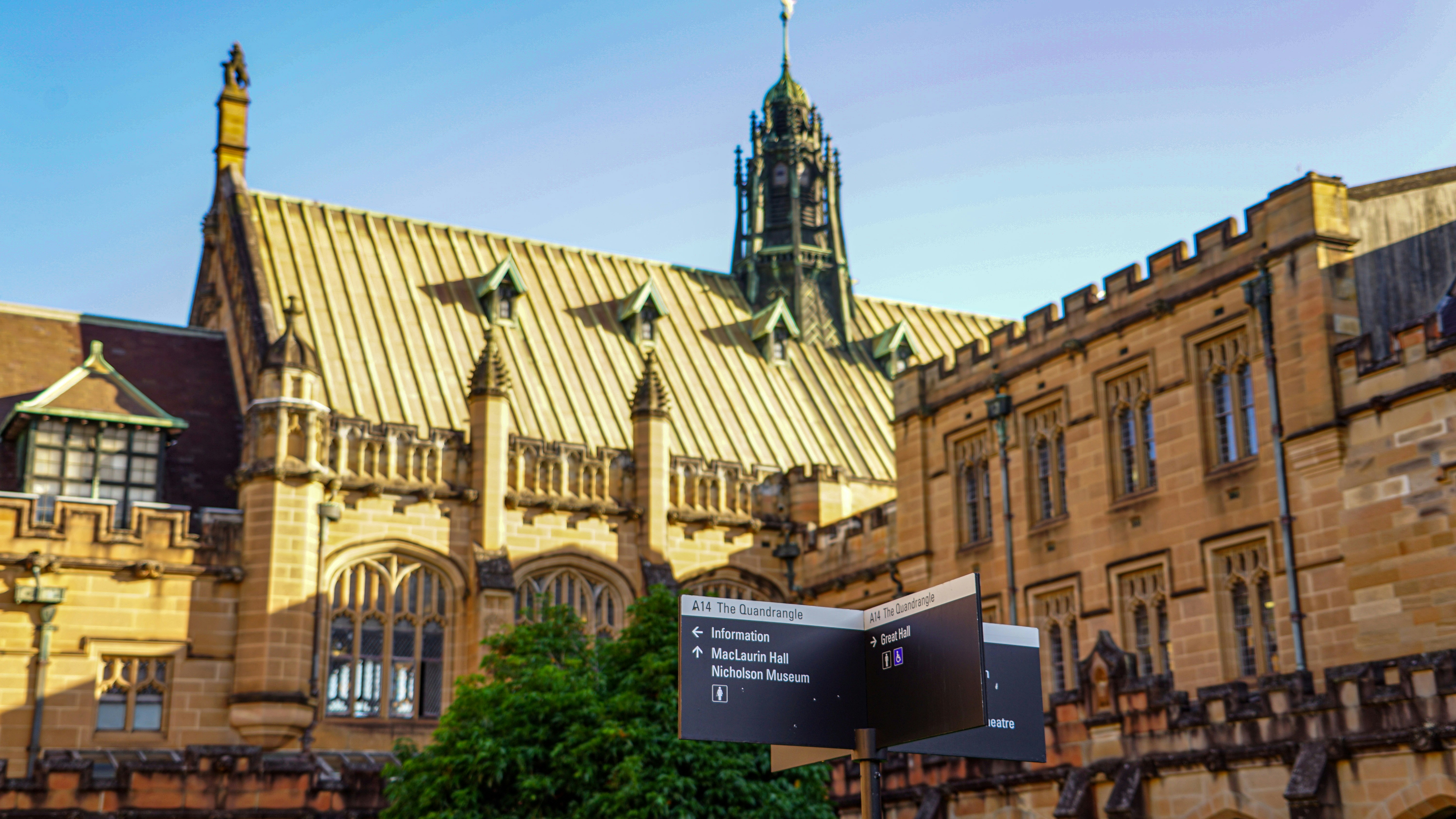 Historic university building with a directional sign