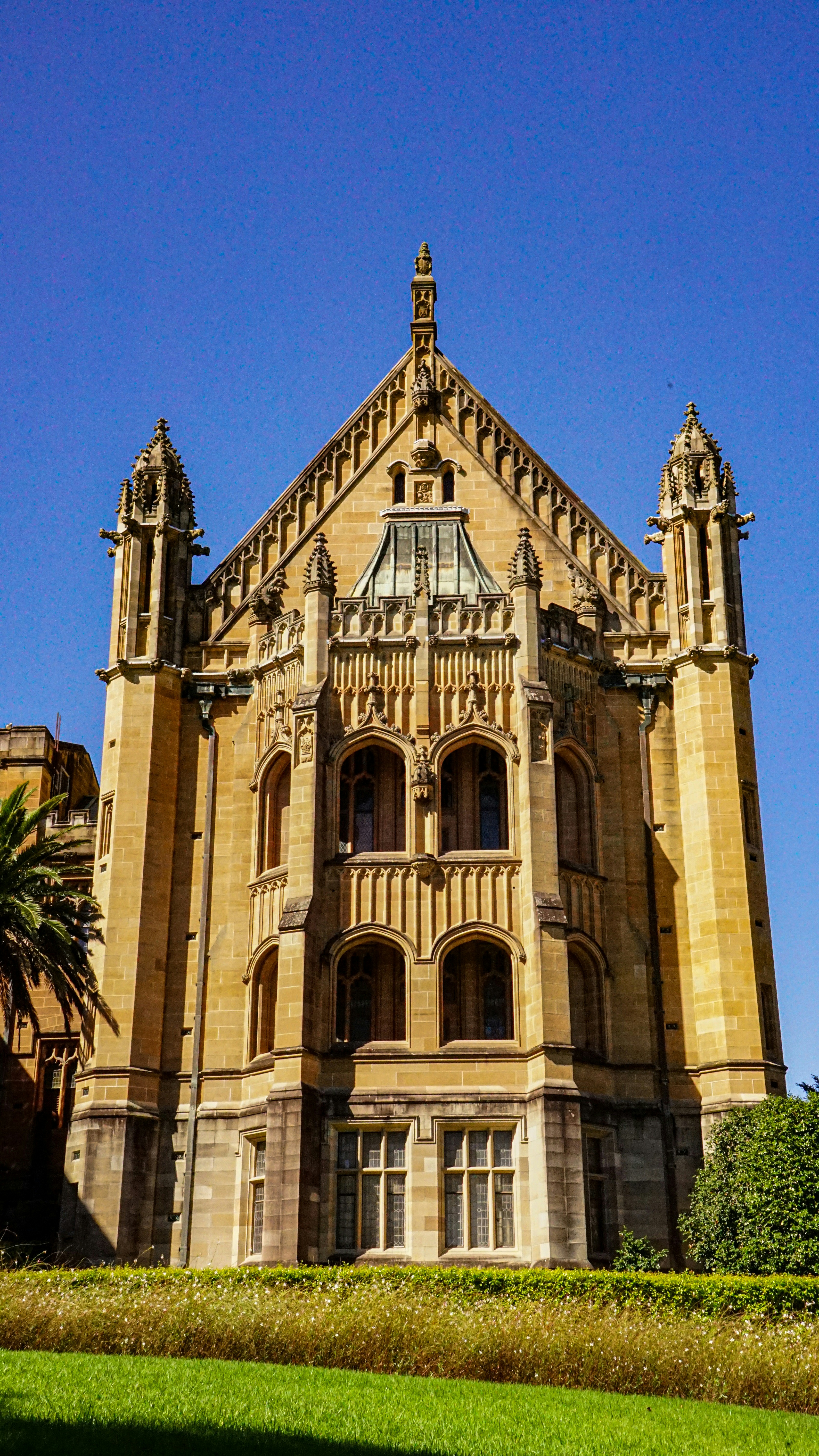 Ornate stone building with arched windows under blue sky.