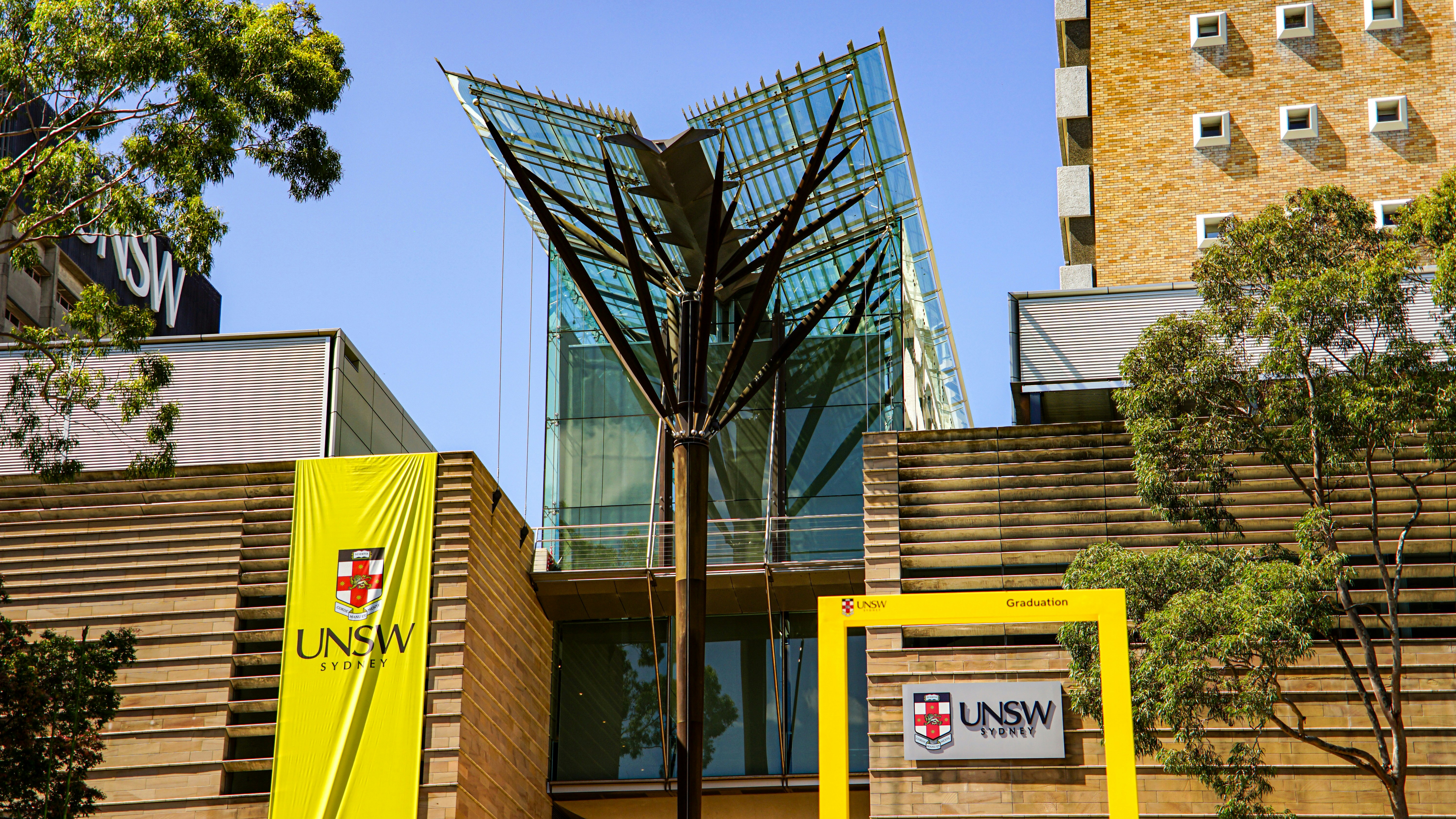Modern glass building with yellow unsw signage