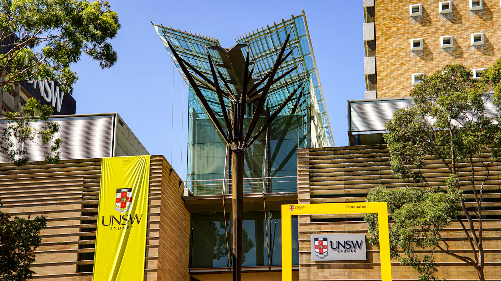 Modern glass building with yellow UNSW signage, Sydney
