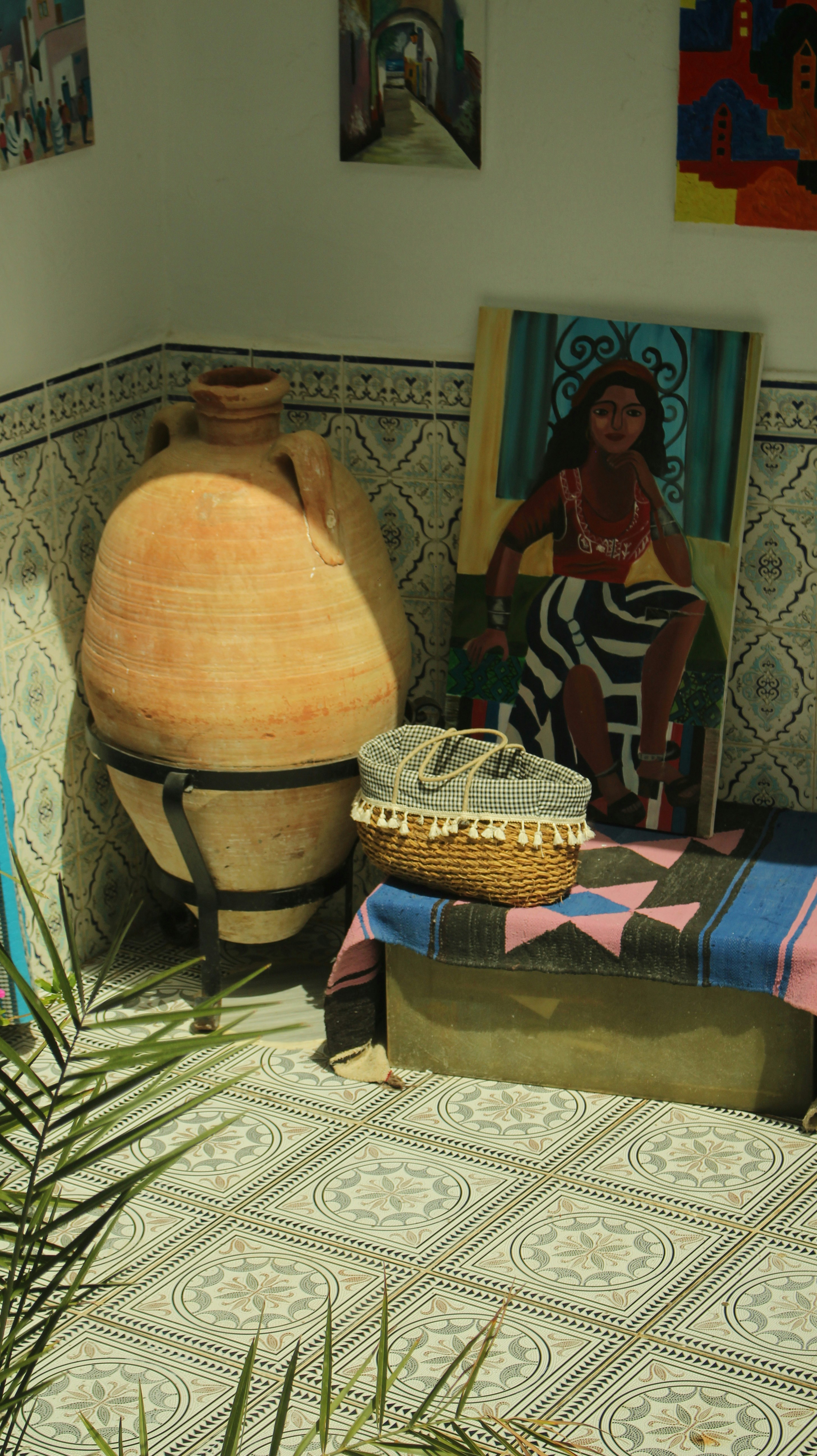 Large clay amphora with woven basket and colorful rug