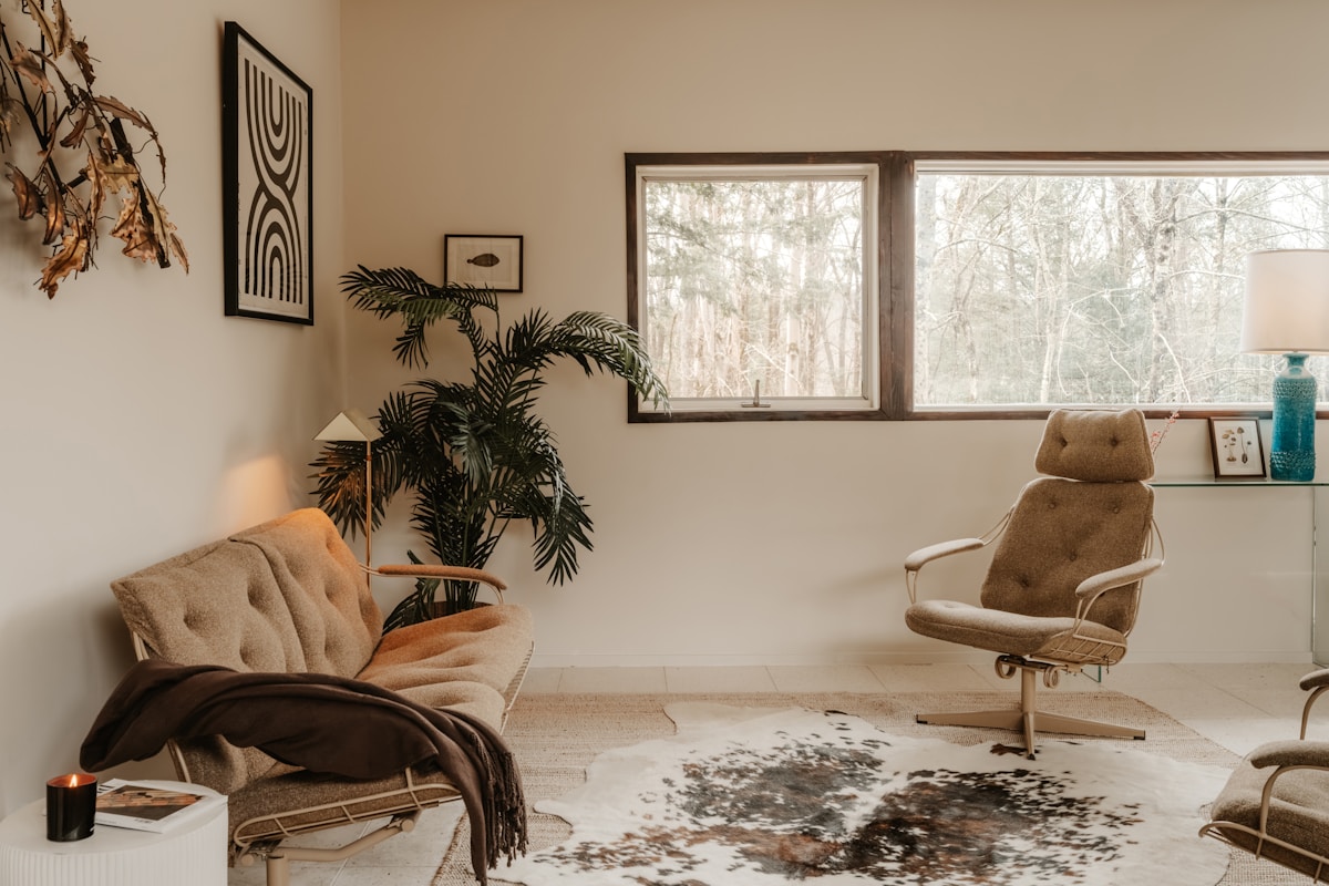 Cozy apartment reading corner with vintage furniture and bare fall trees through window