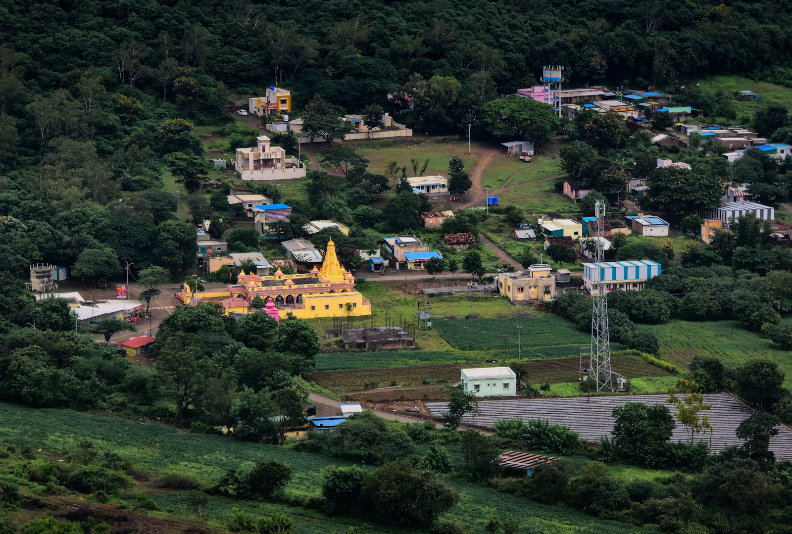 A village and temple among forested hills, seen from above