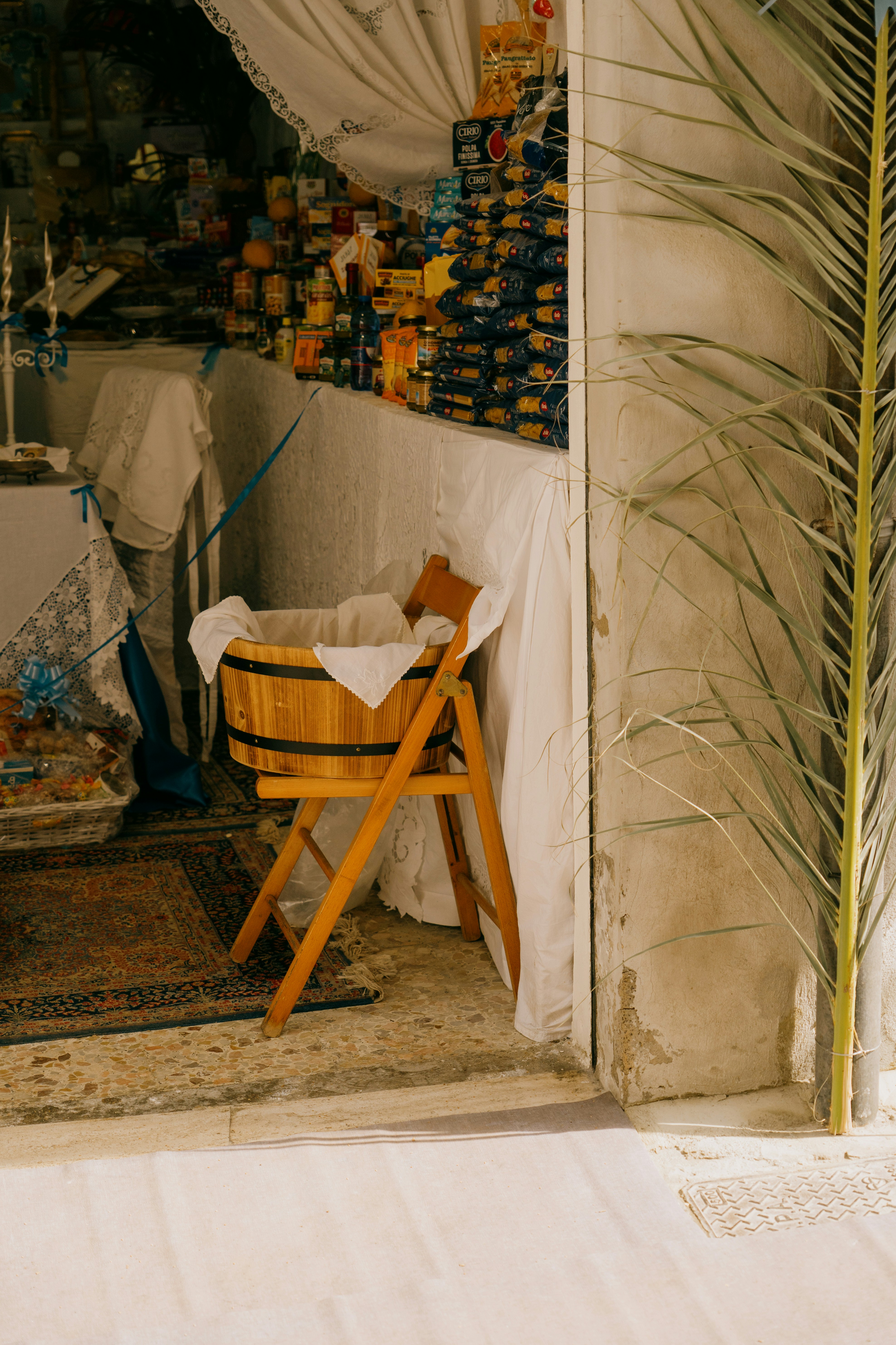 Wooden cradle with white linens on a stand.