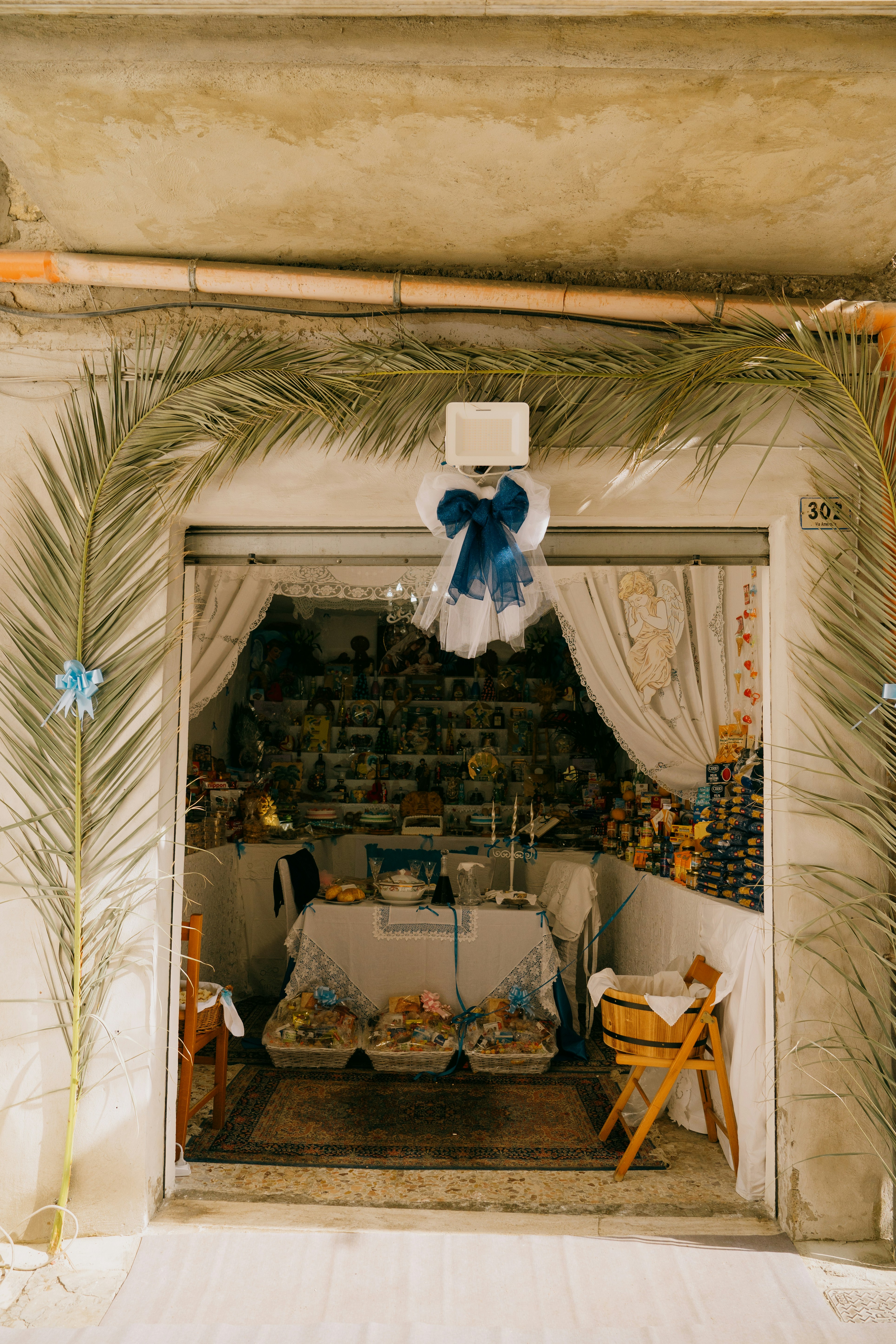 Shop entrance decorated with palm fronds and blue bows