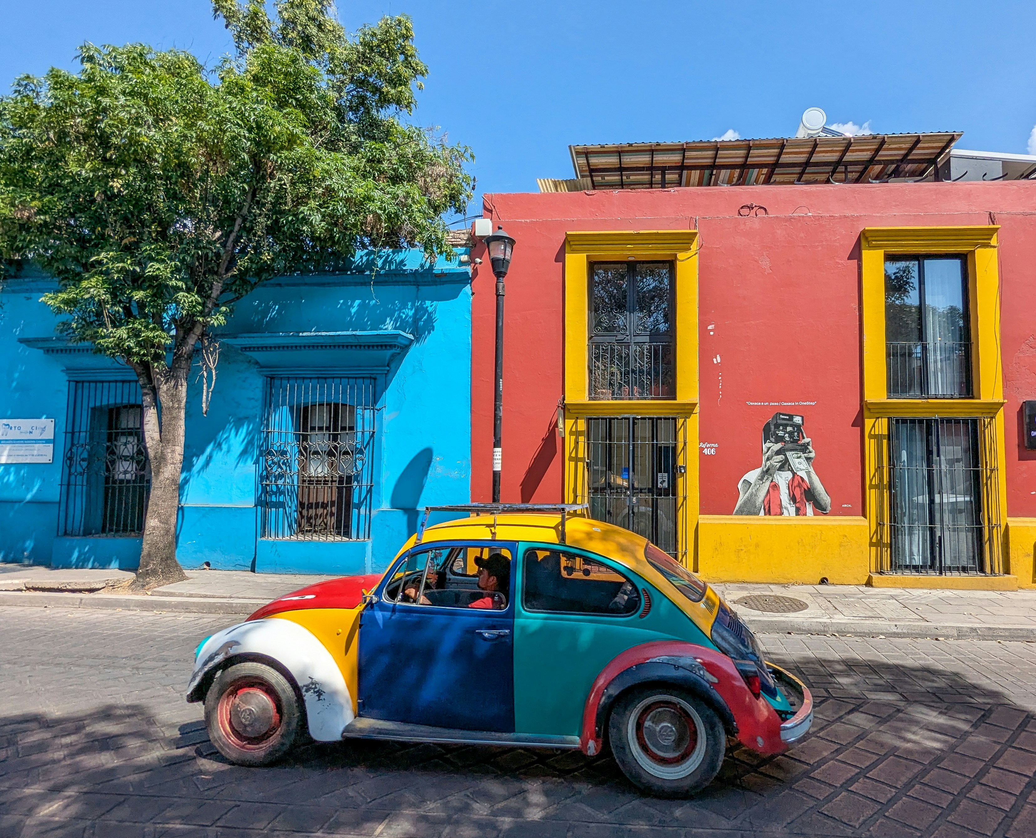 Um colorido Volkswagen Fusca estacionado ao lado de prédios coloridos e pintados.