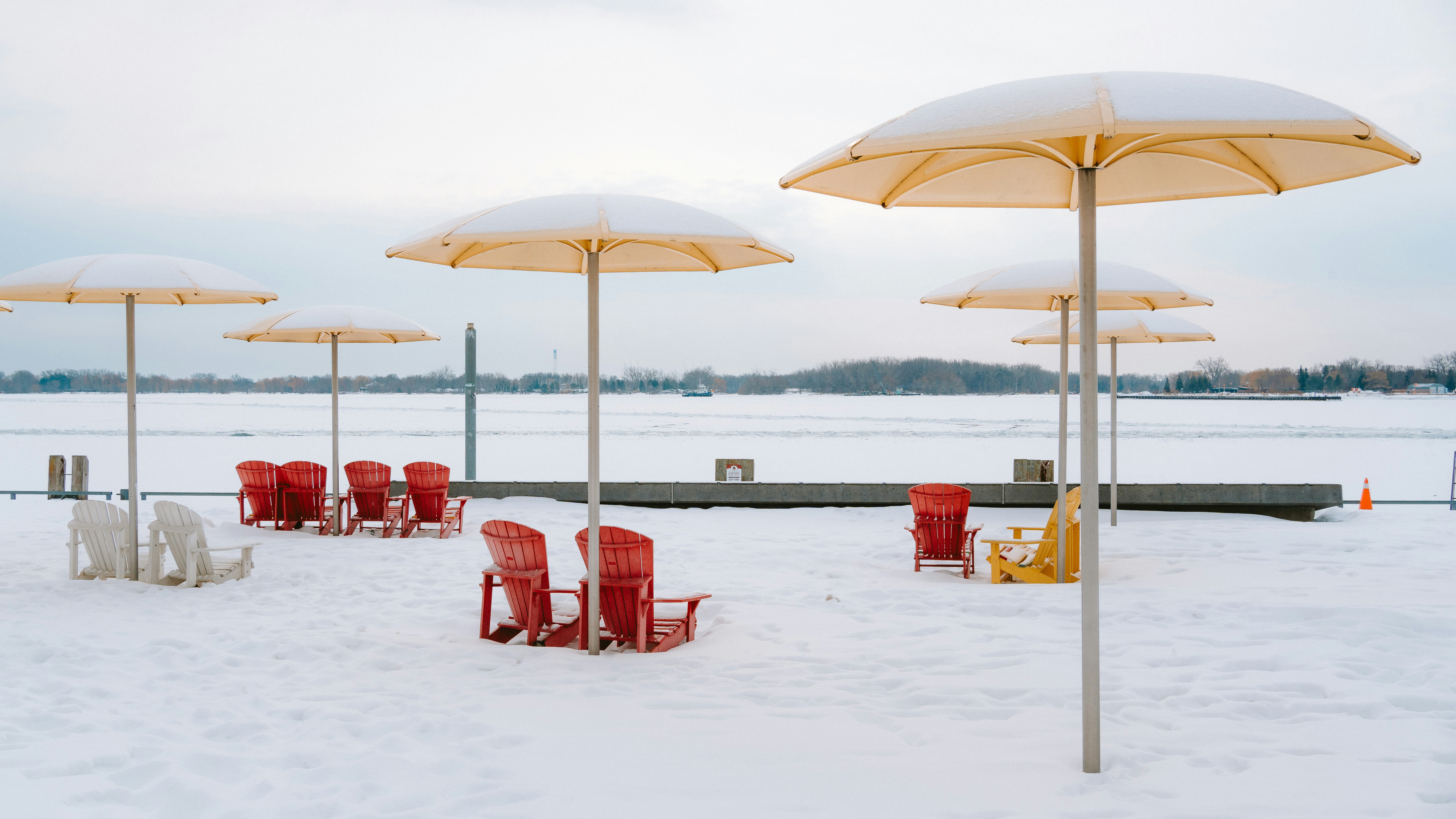 Leere Strandstühle und Sonnenschirme im Schnee