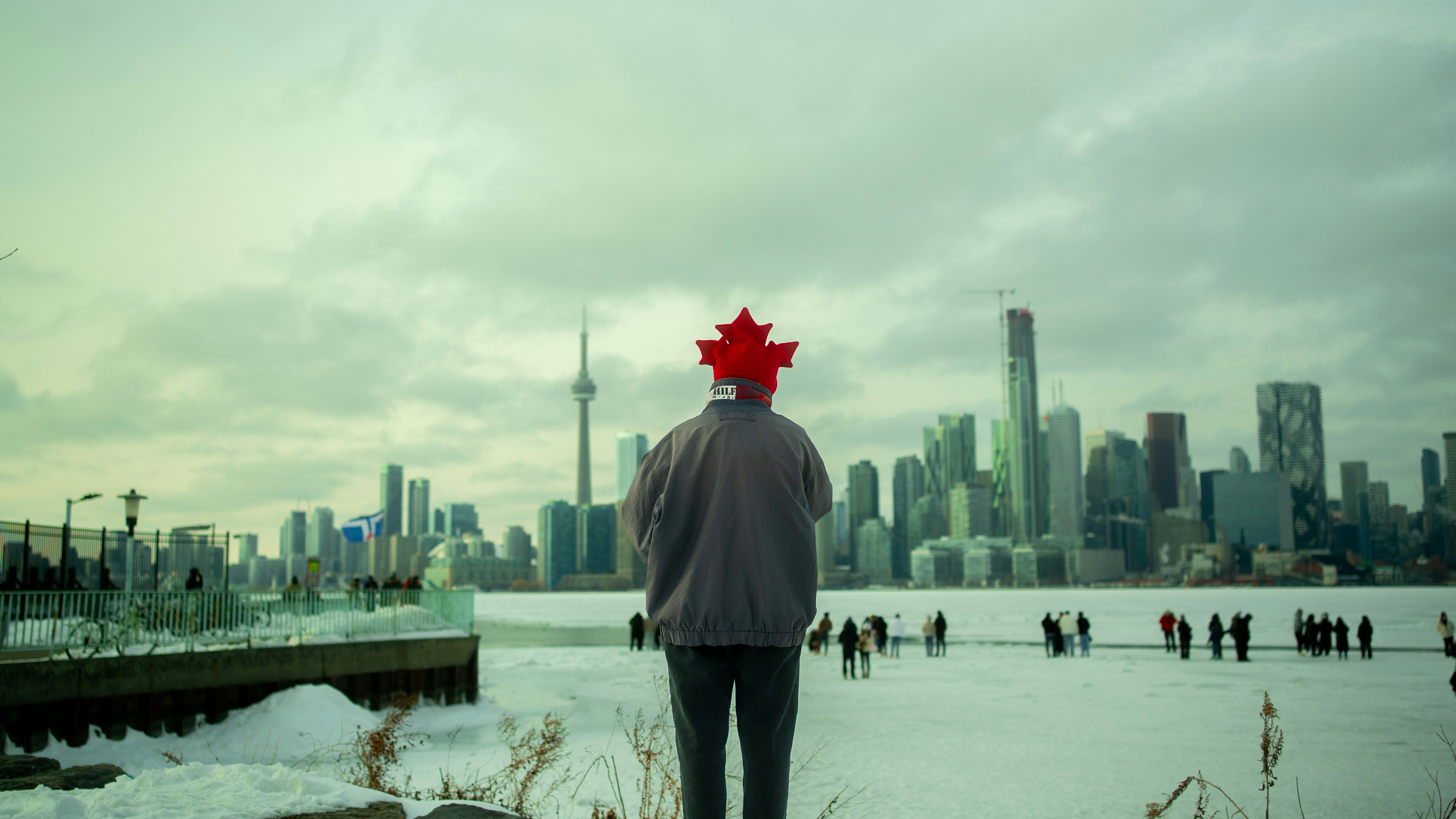 Mann mit kanadischer Flaggenhut blickt auf die Skyline von Toronto