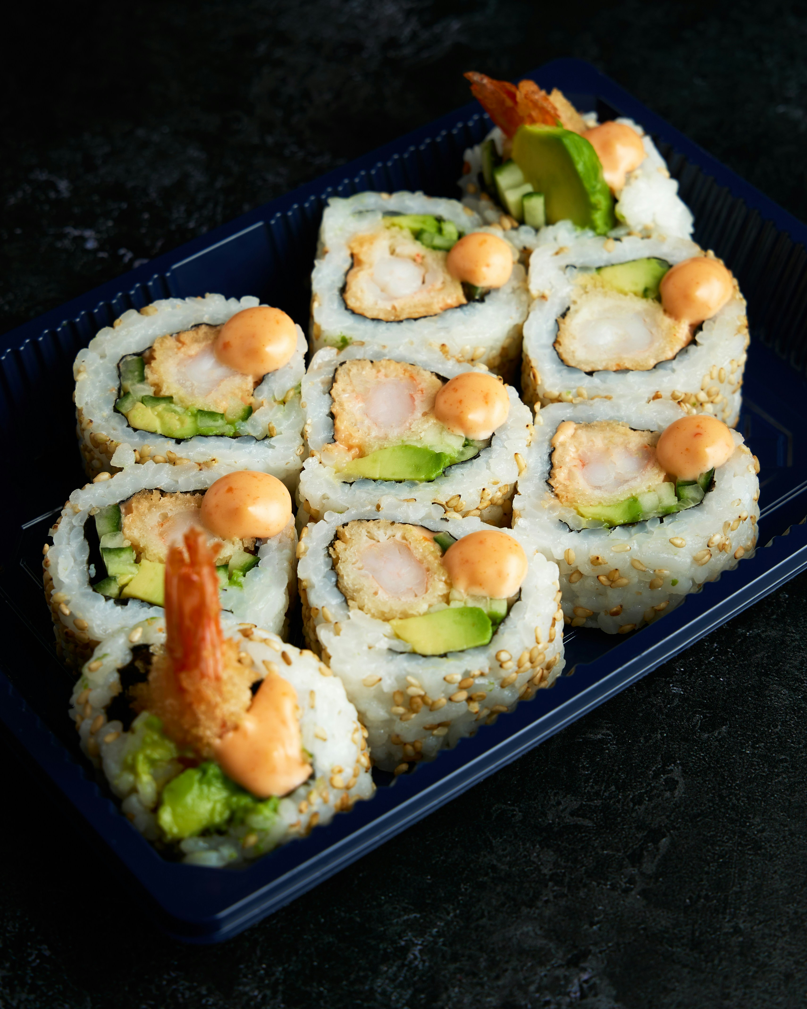 Rollitos de sushi de gambas fritas con aguacate y mayonesa picante