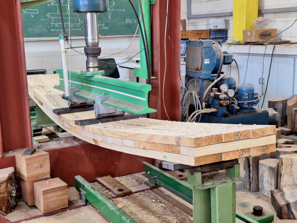 Wooden beams being tested under a machine.