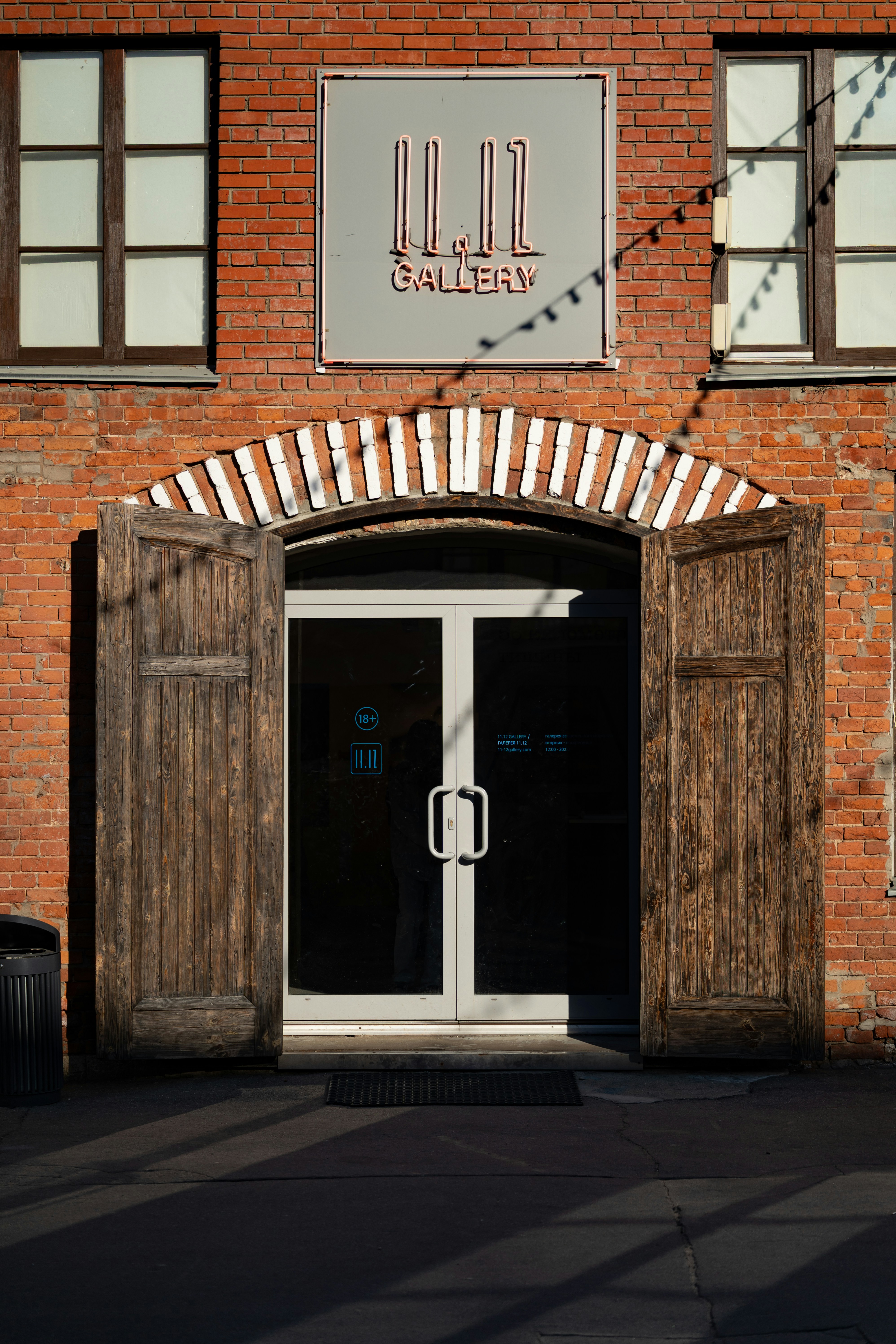 Gallery entrance with open wooden doors and sign.