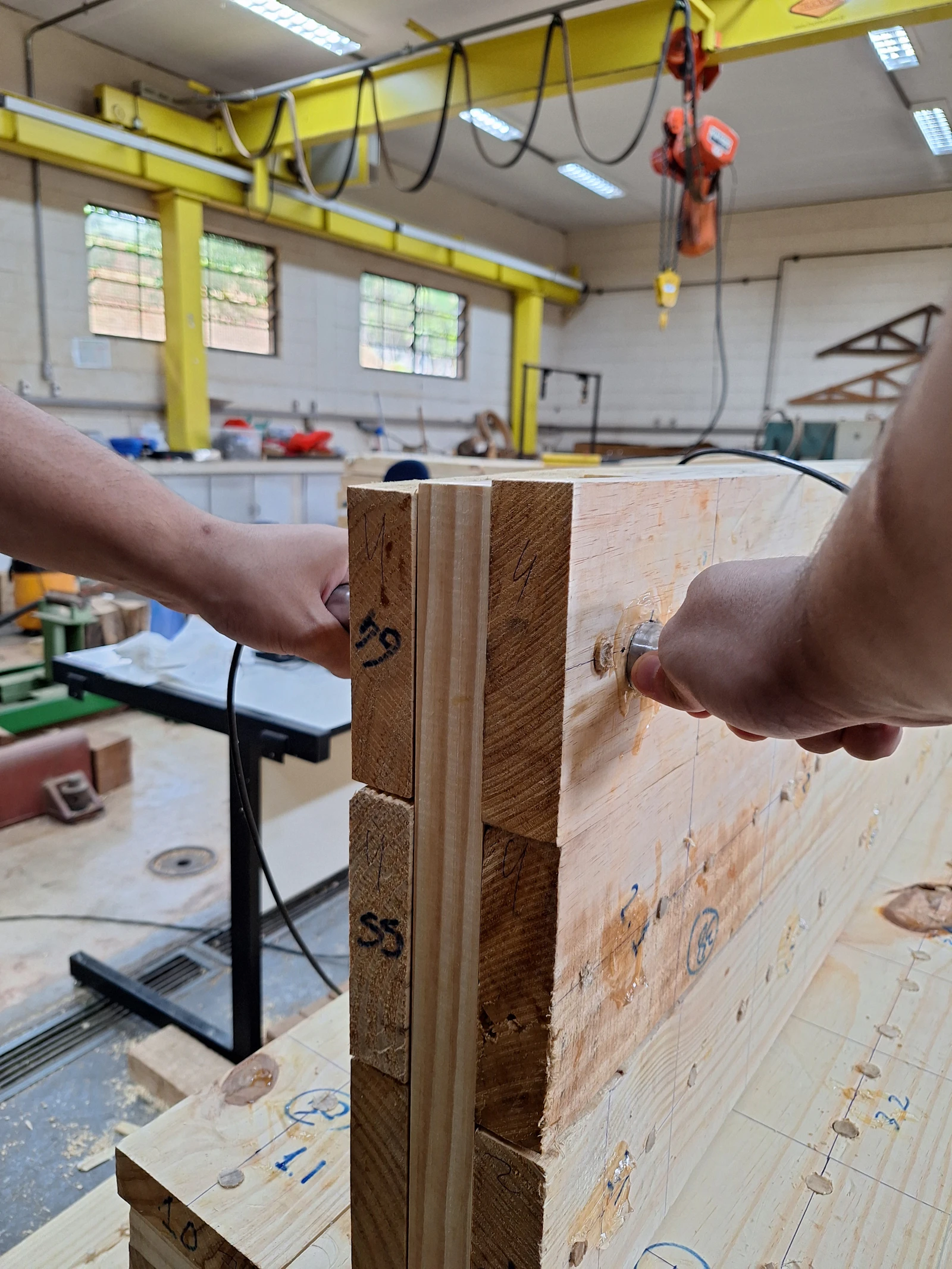 Hands assembling metal fasteners on a structural beam