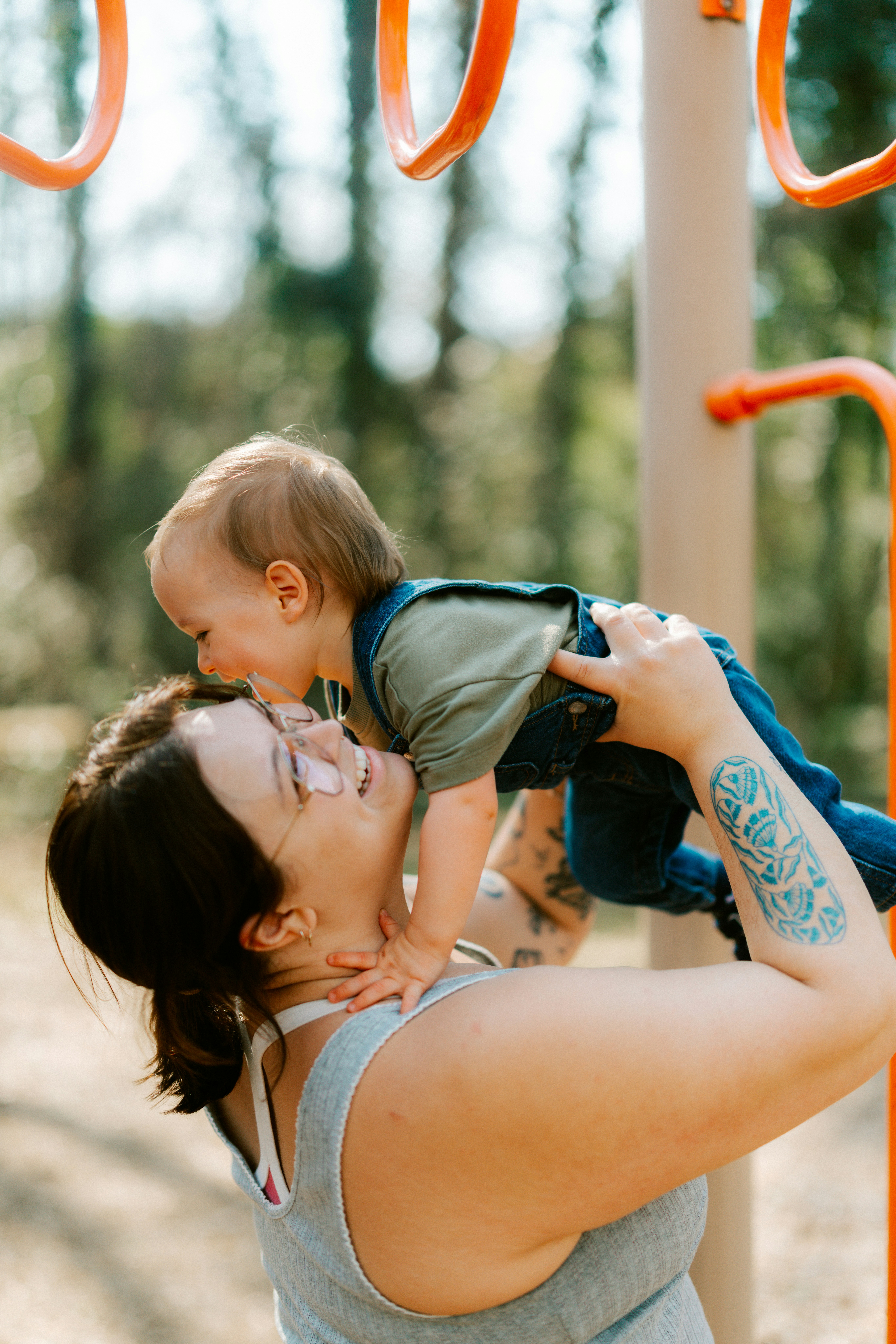 Maman tient le bébé au terrain de jeu