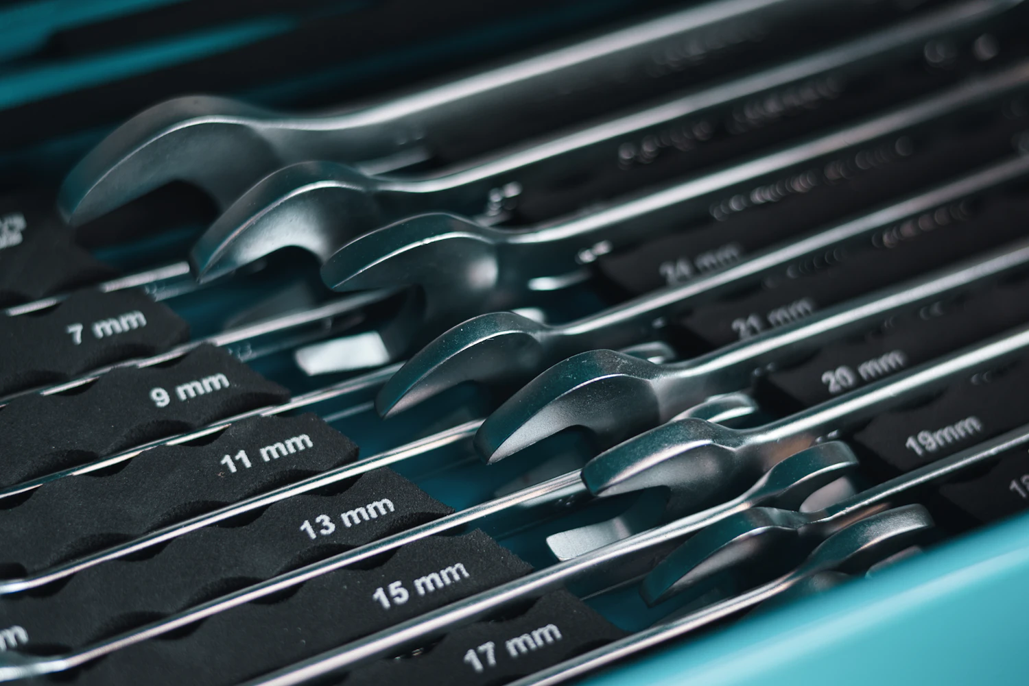 Metal hand wrenches organized inside a workshop toolbox