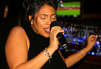 A woman singing passionately into a microphone