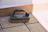 A black handled scrubbing brush on paving stones