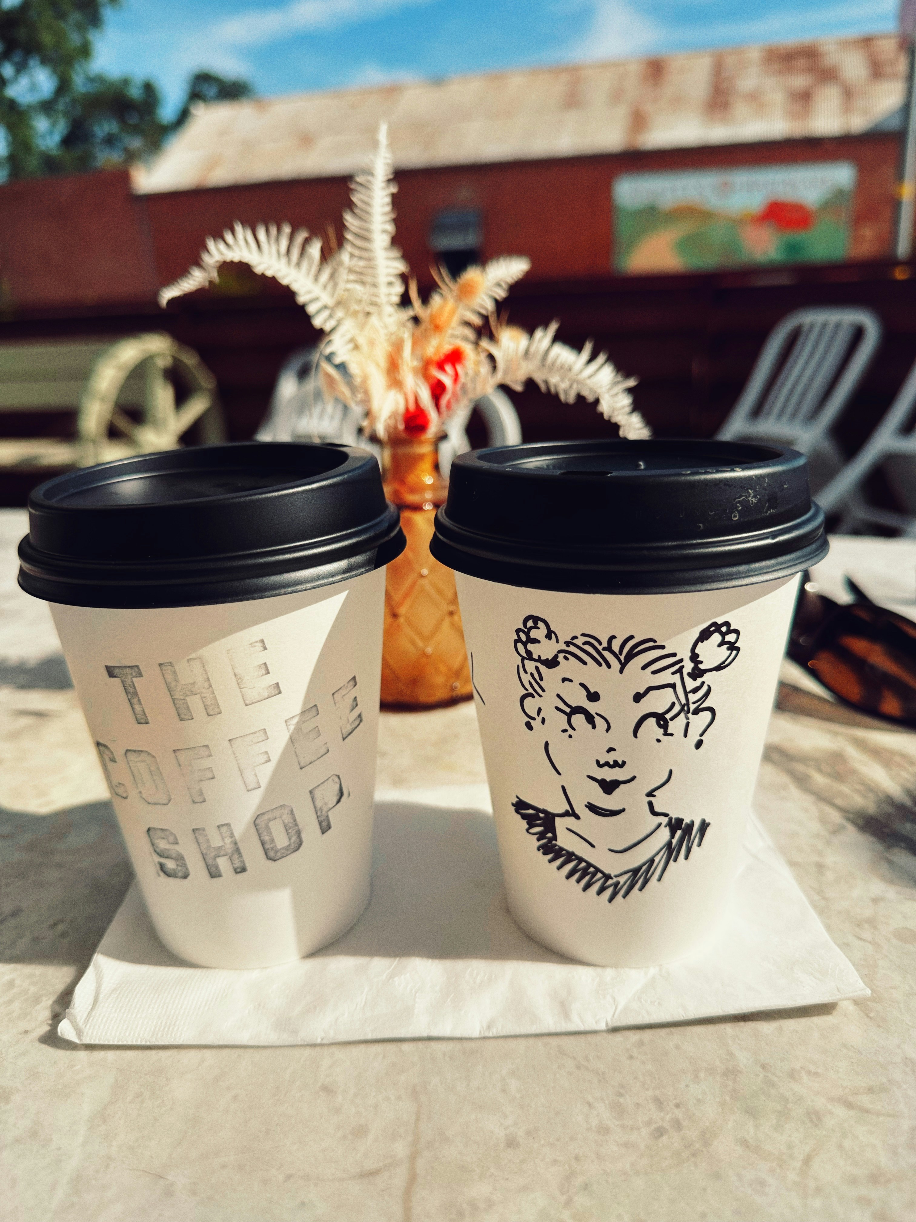 Two coffee cups on a table outside