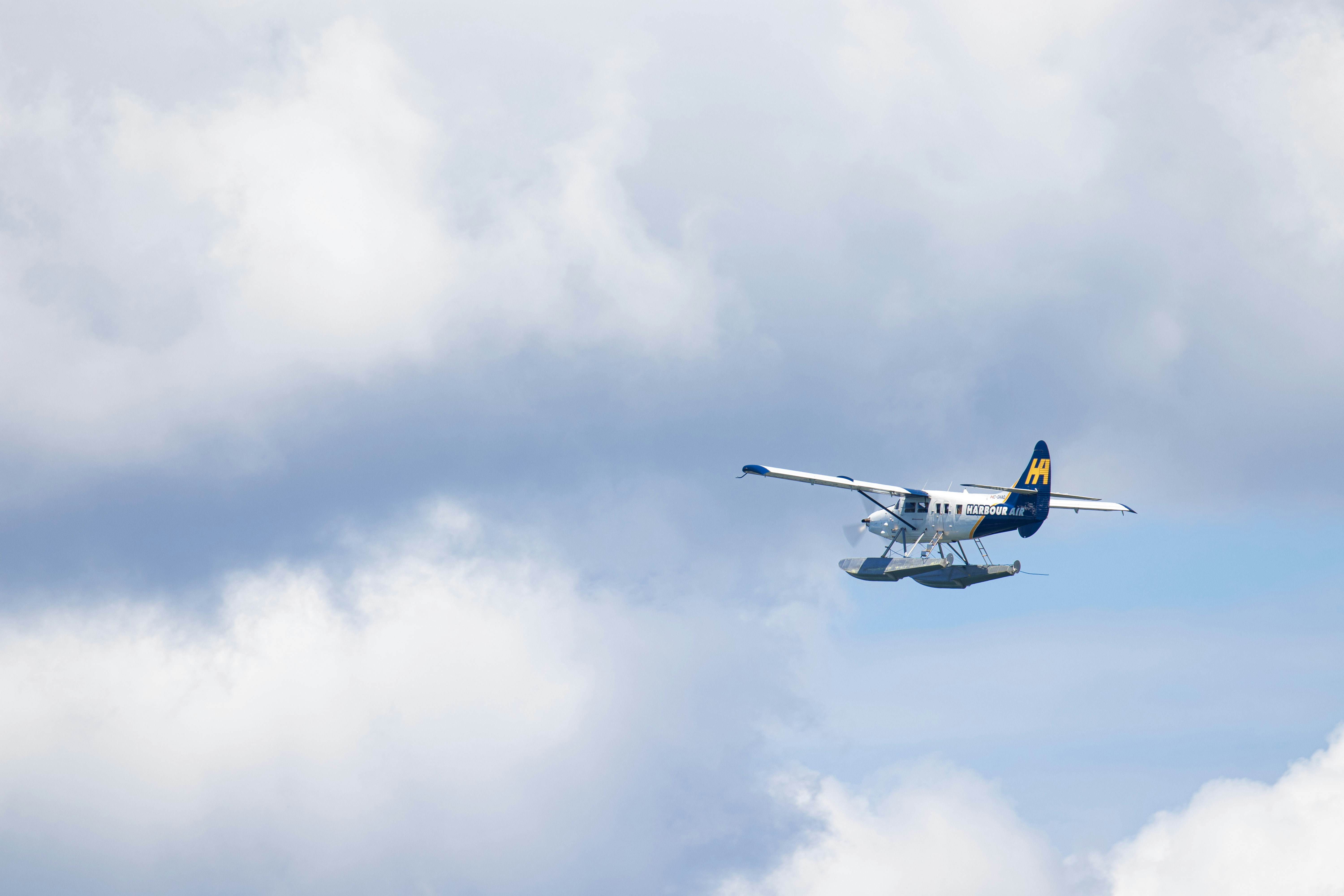 Un hydravion traverse un ciel nuageux.