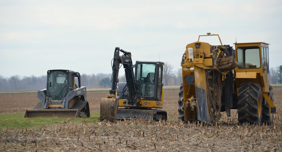 Loader, excavator and land equipment staged across an open lot