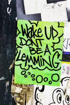 Green paper with "wake up dont be a lemming" text