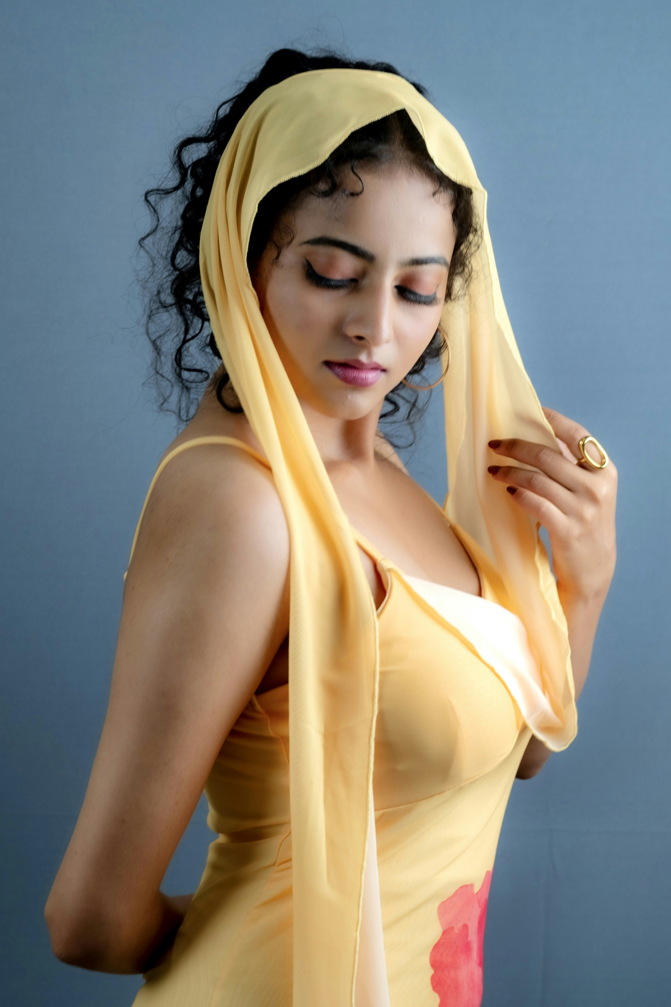A woman with curly hair wearing a yellow dress