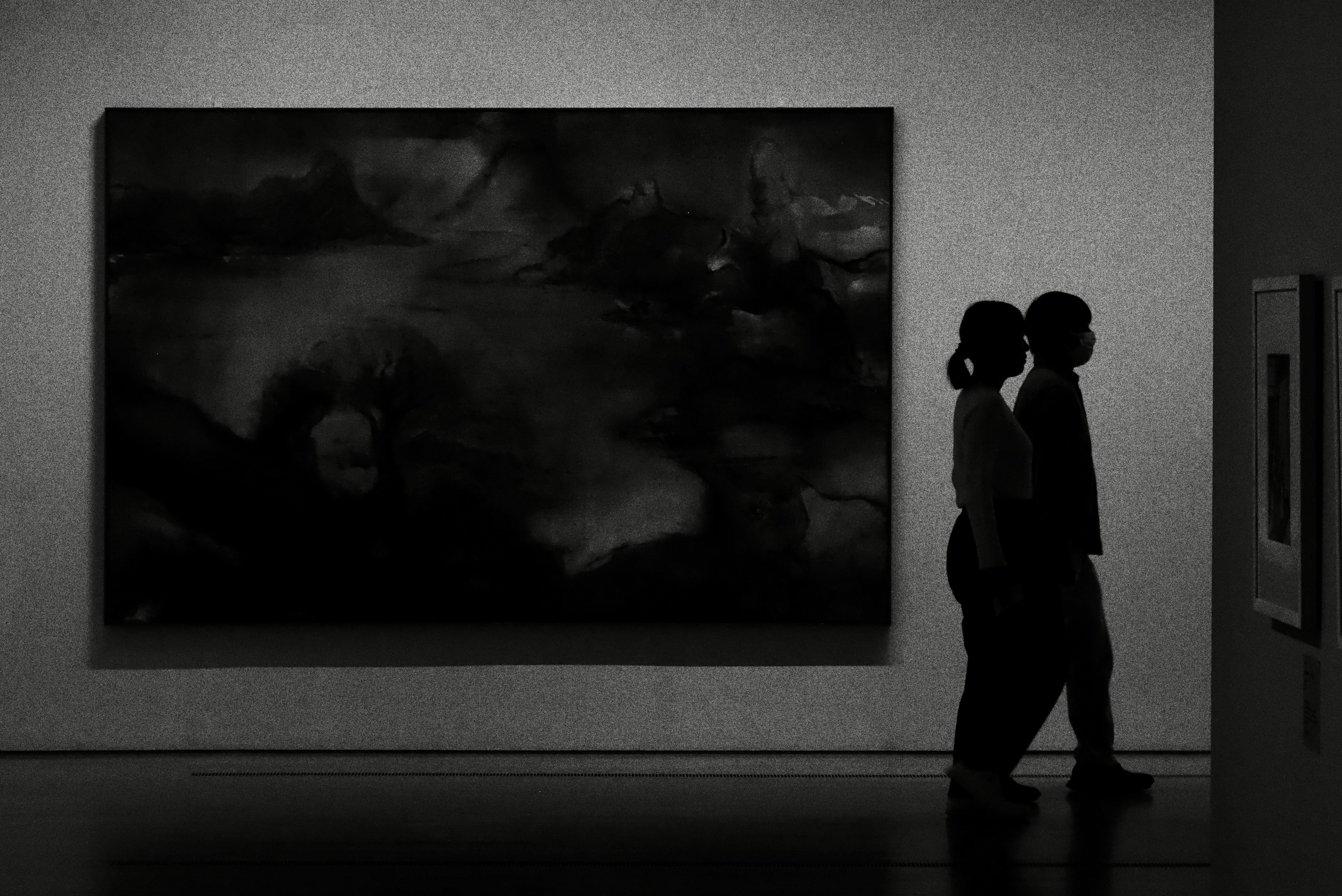 Deux personnes admirent l’art abstrait dans une galerie.