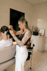 A tattooed hairstylist styles a woman's hair