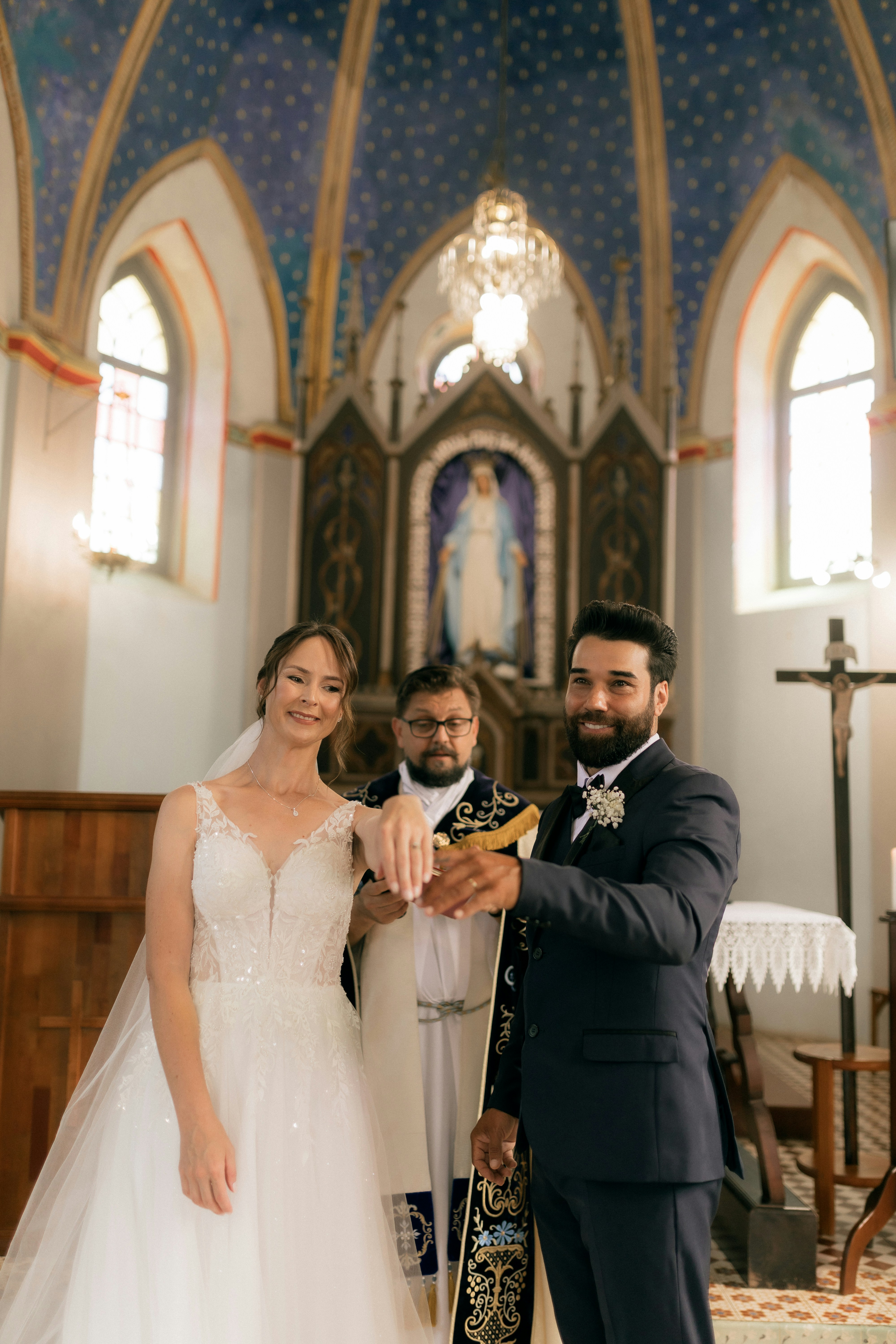 A bride and groom exchange rings during a church wedding.