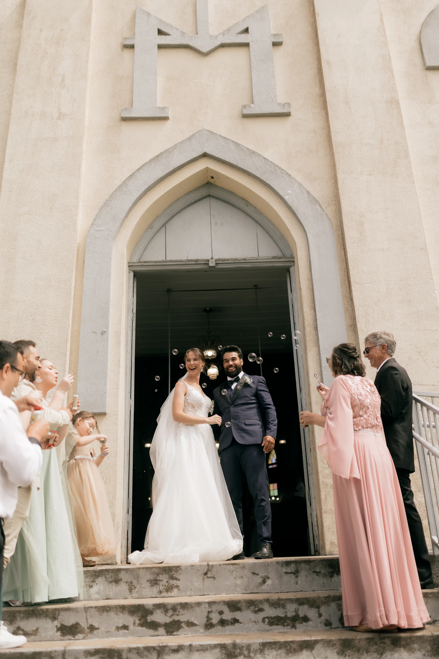 Wedding reception exit ideas beyond sparklers — Guests blow bubbles as the couple makes their grand exit.