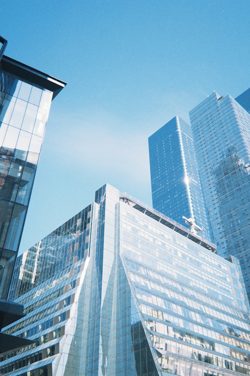 Modern glass skyscrapers in a financial district against a clear blue sky