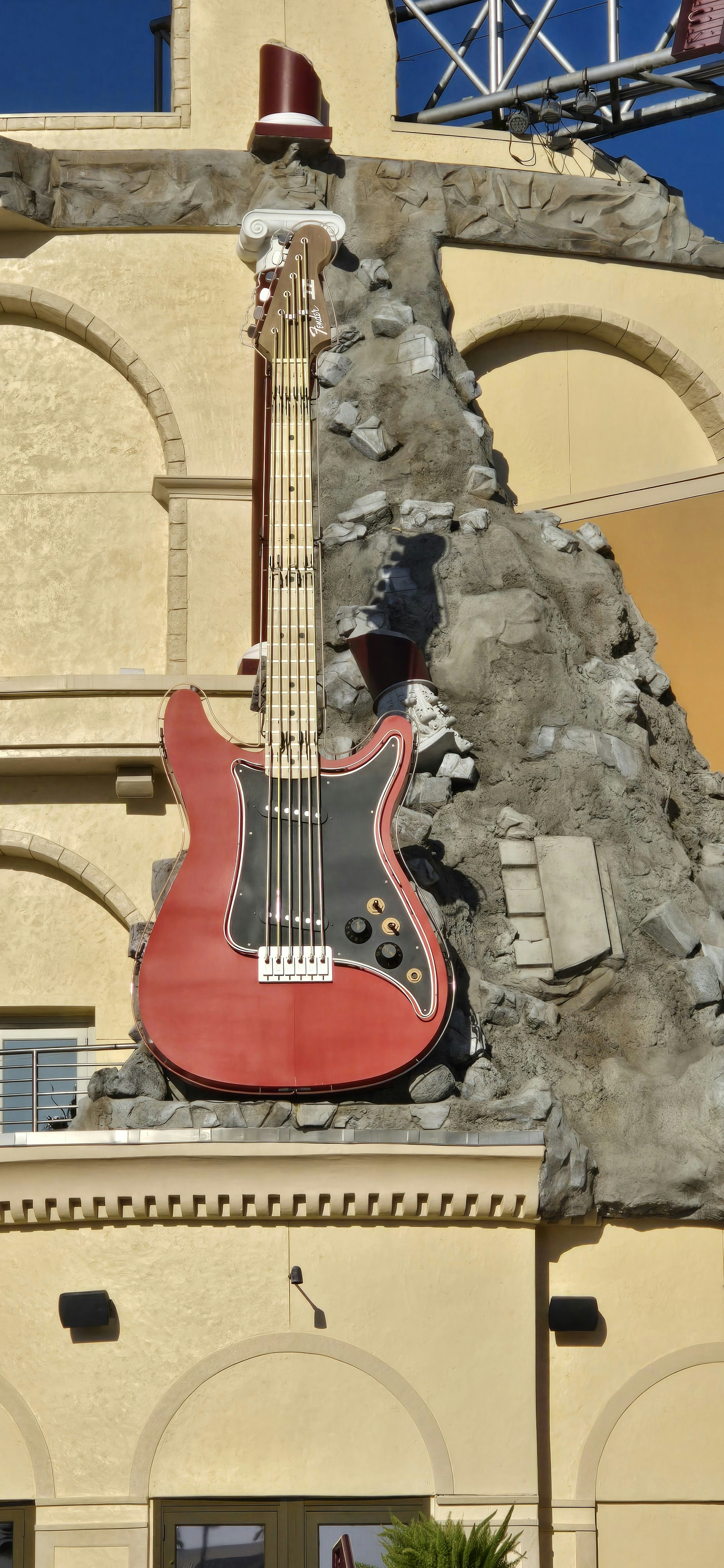 Patung gitar merah raksasa di fasad bangunan