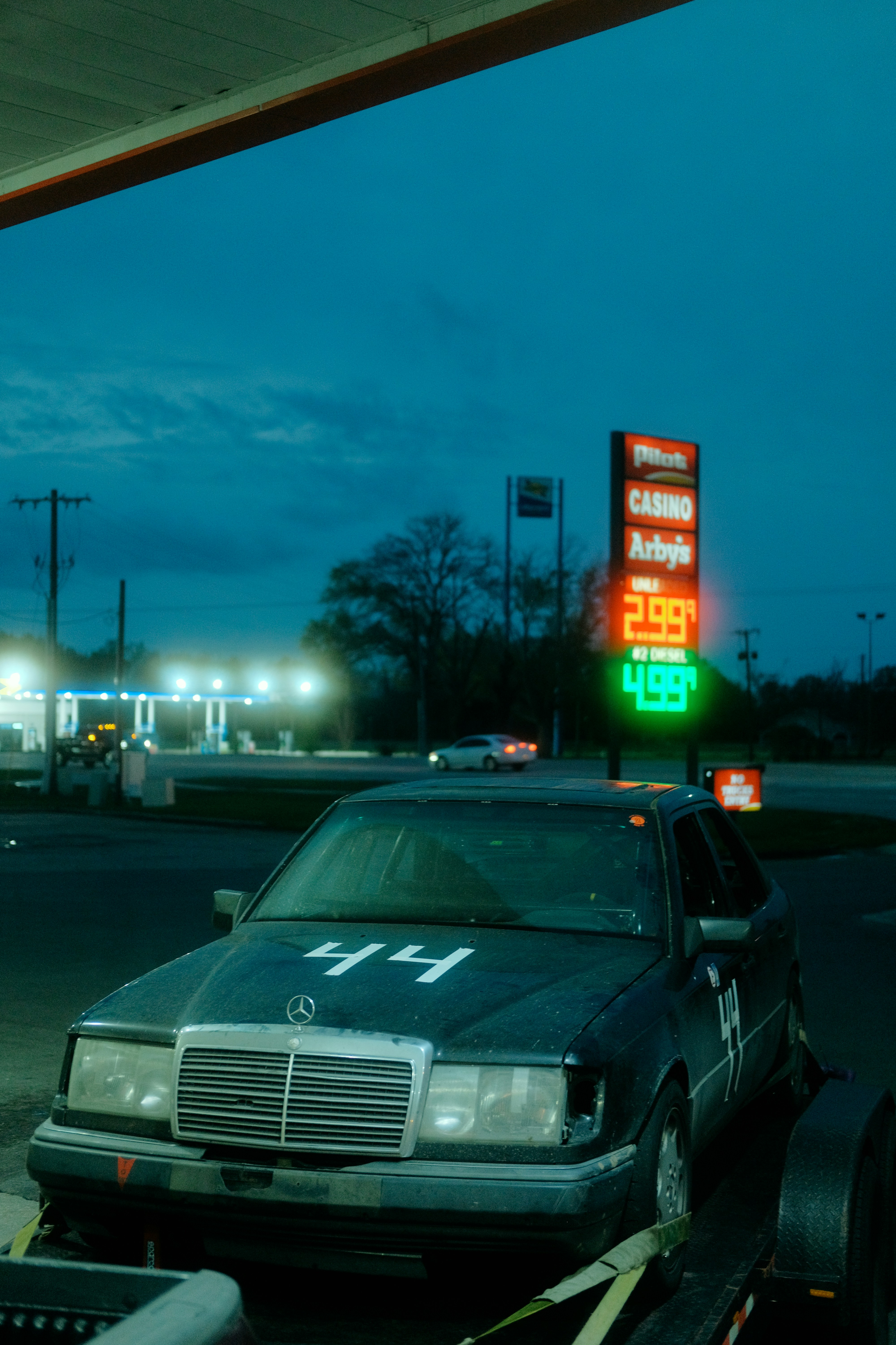 Car with number 44 at a gas station at dusk