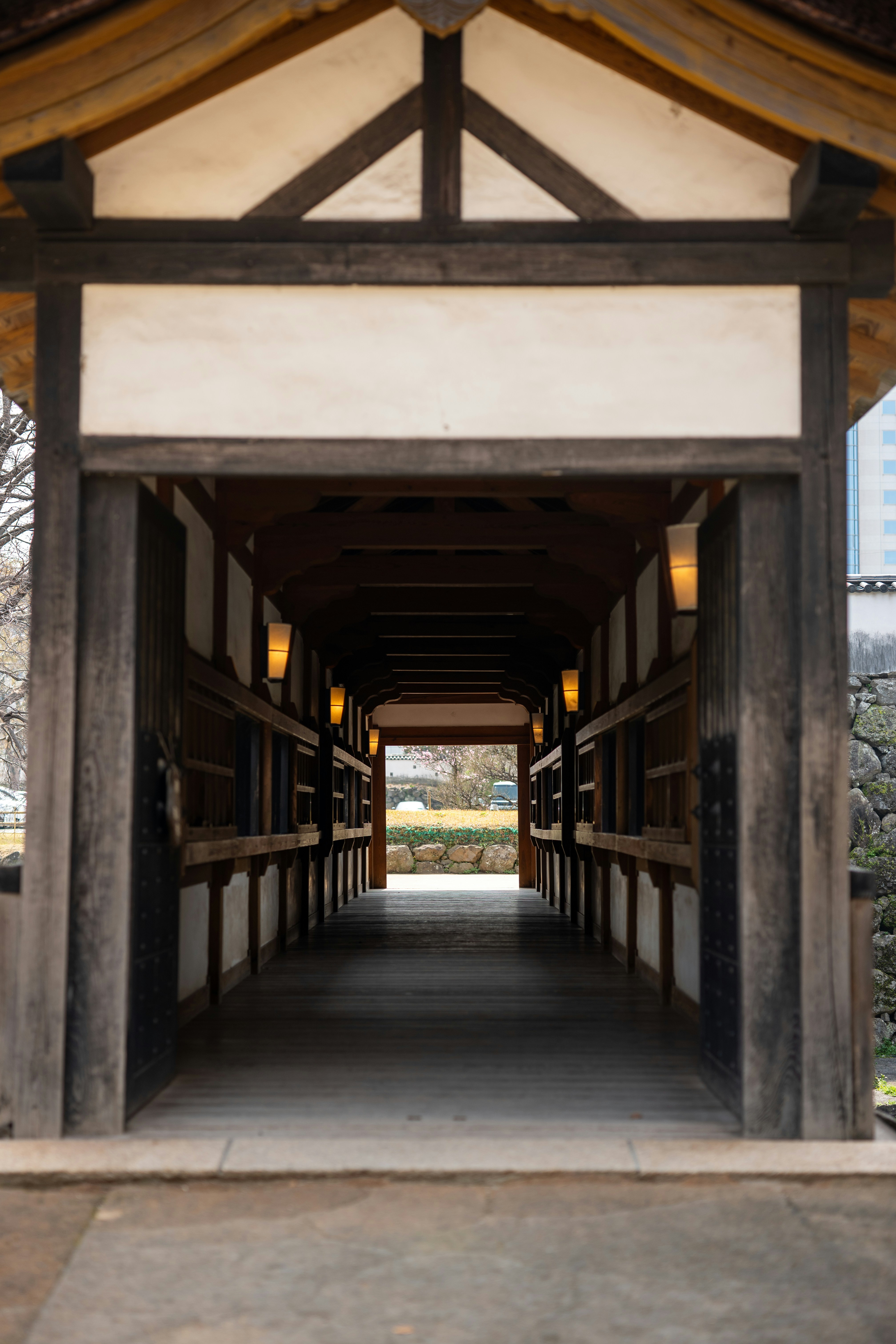 Corredor longo de madeira com luzes que levam para fora