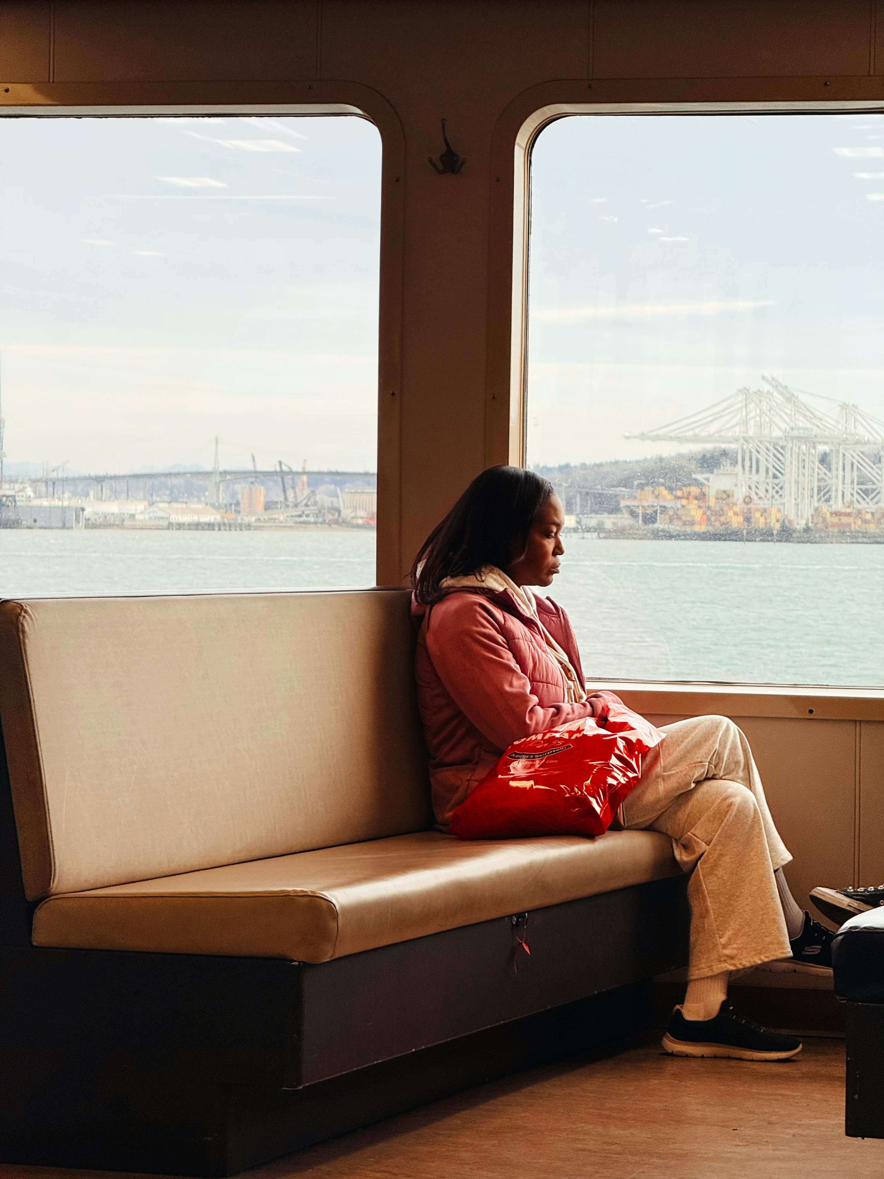 Femme assise sur un ferry regardant par la fenêtre