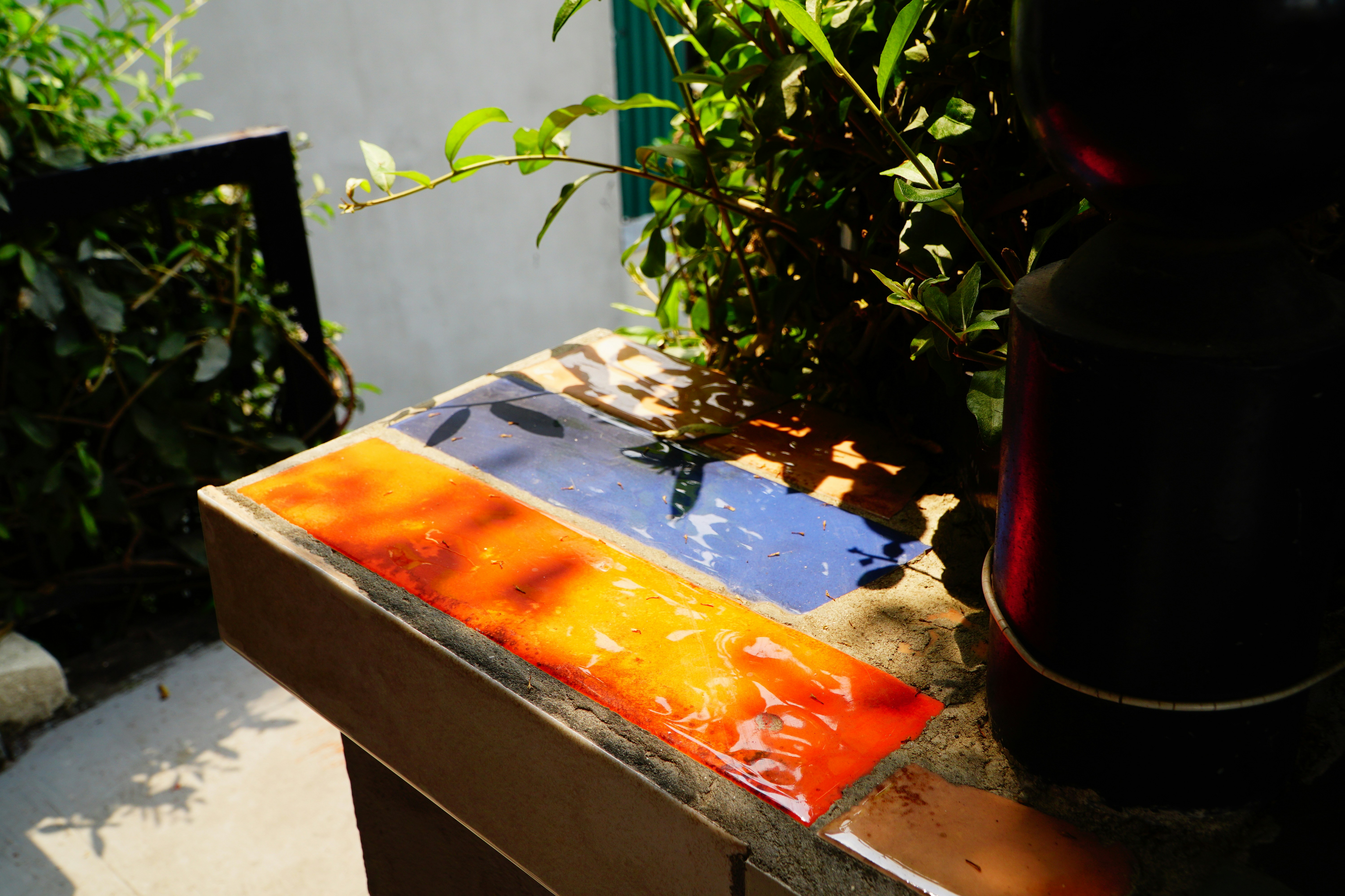 Colorful glass tiles arranged on a surface outdoors.