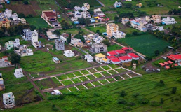 Aerial view of a residential area with houses and plots.