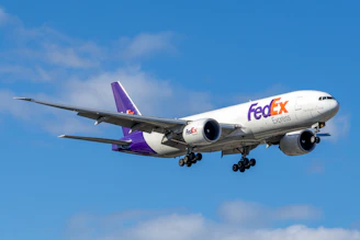 Fedex cargo plane flying in a blue sky.