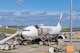 Cargo plane being loaded at an airport tarmac.