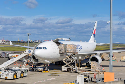 Cargo plane being loaded at an airport tarmac.