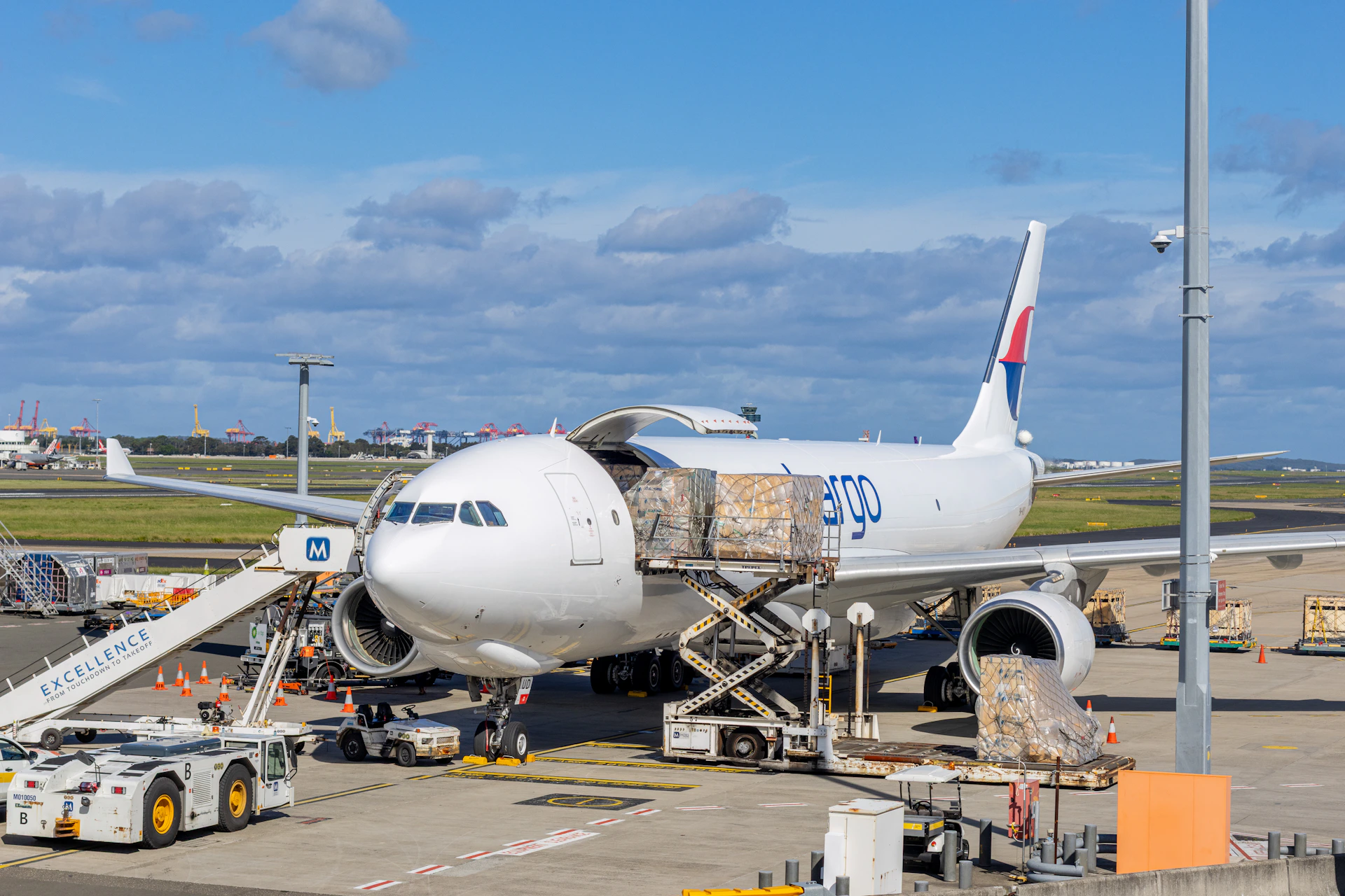 Cargo plane being loaded at an airport tarmac.