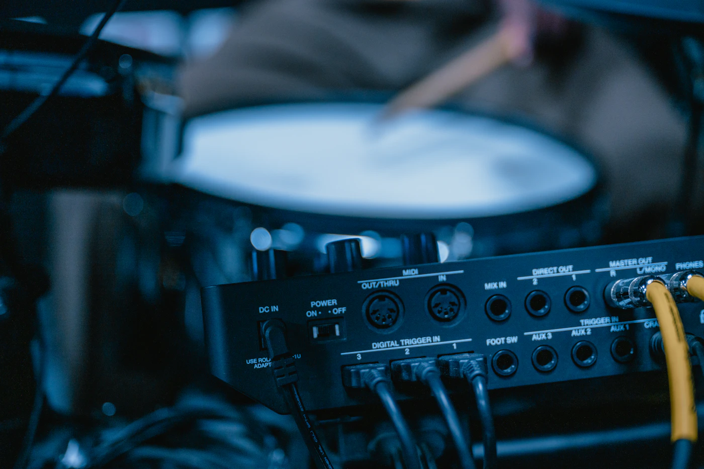Drummer playing drums near studio equipment