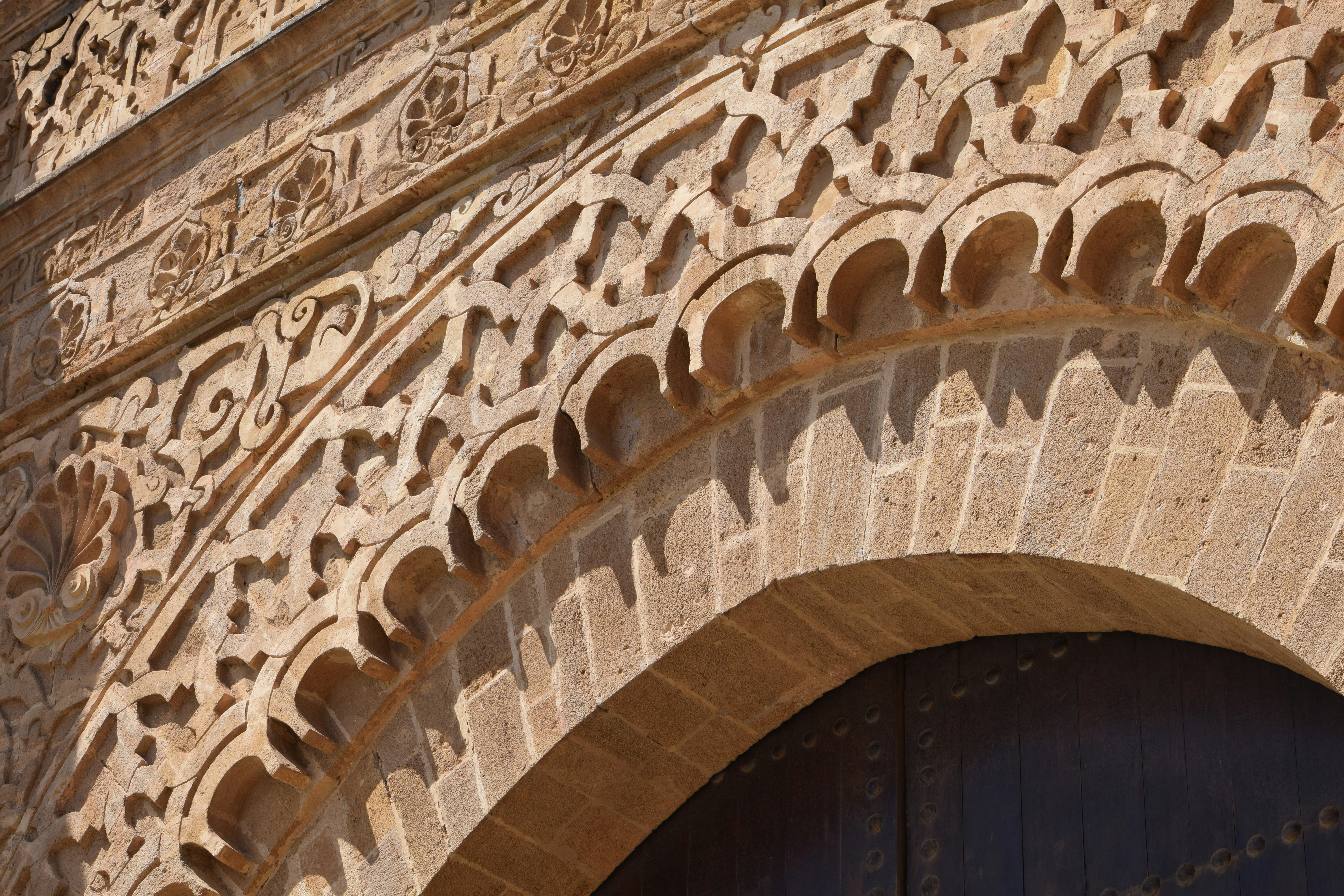 Détail de sculpture en pierre au-dessus d'une arcade en plein cintre