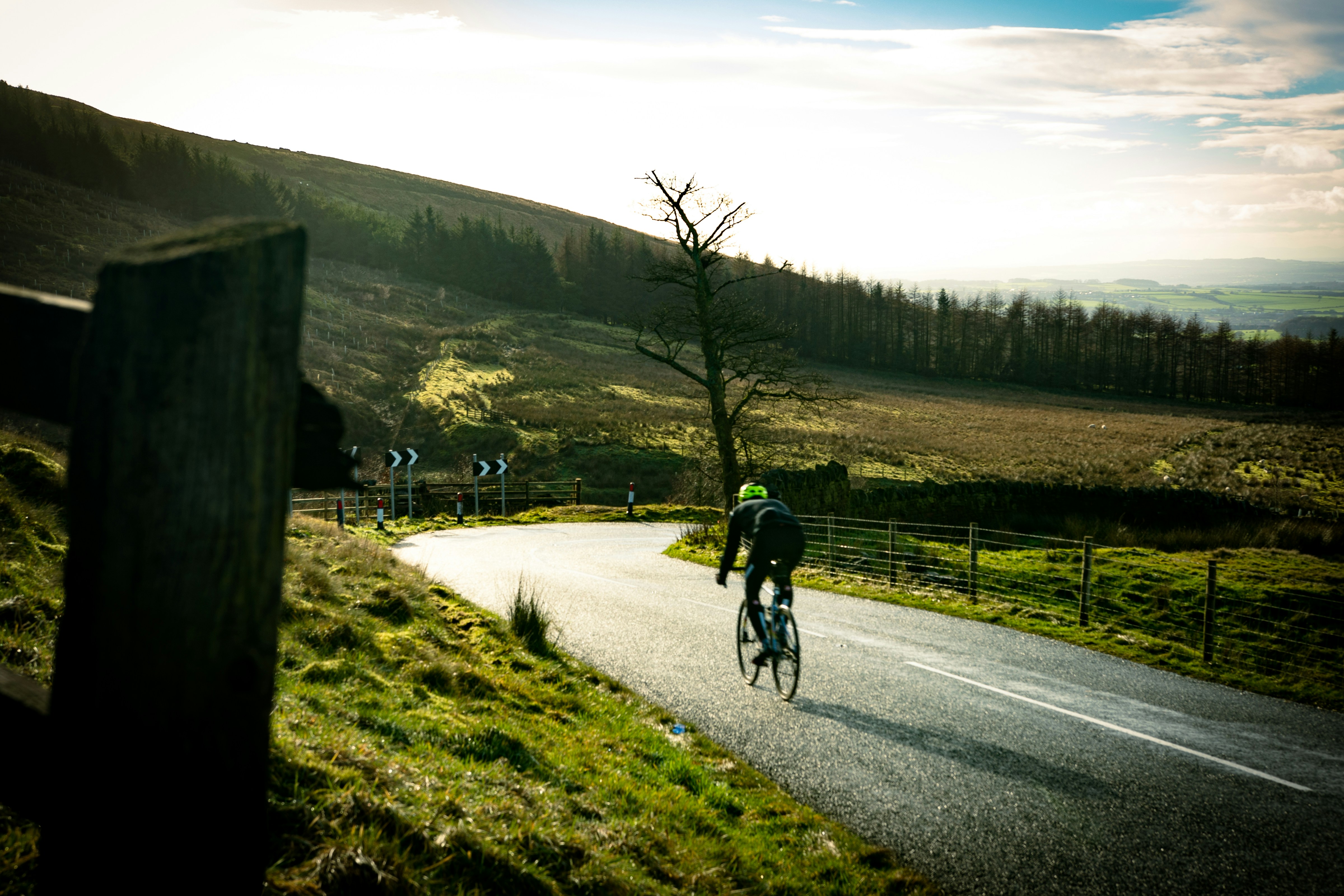 Cyclist riding on a winding road through hills