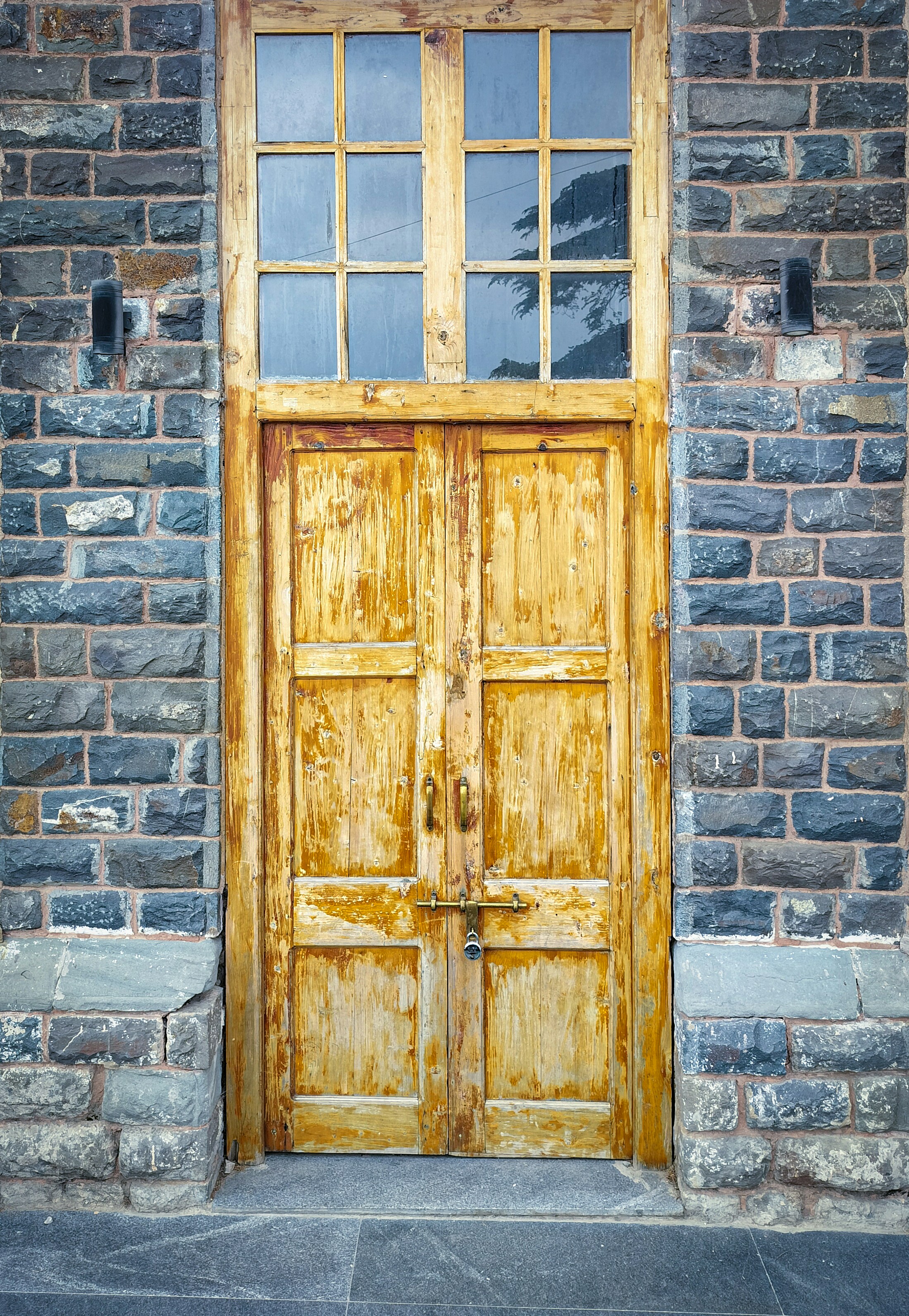 Rustic wooden double doors set in stone wall