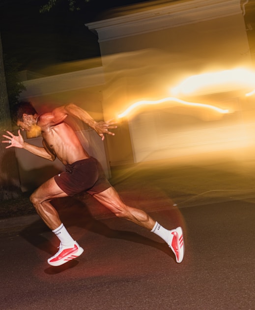 Man running fast on a dark street at night with motion blur