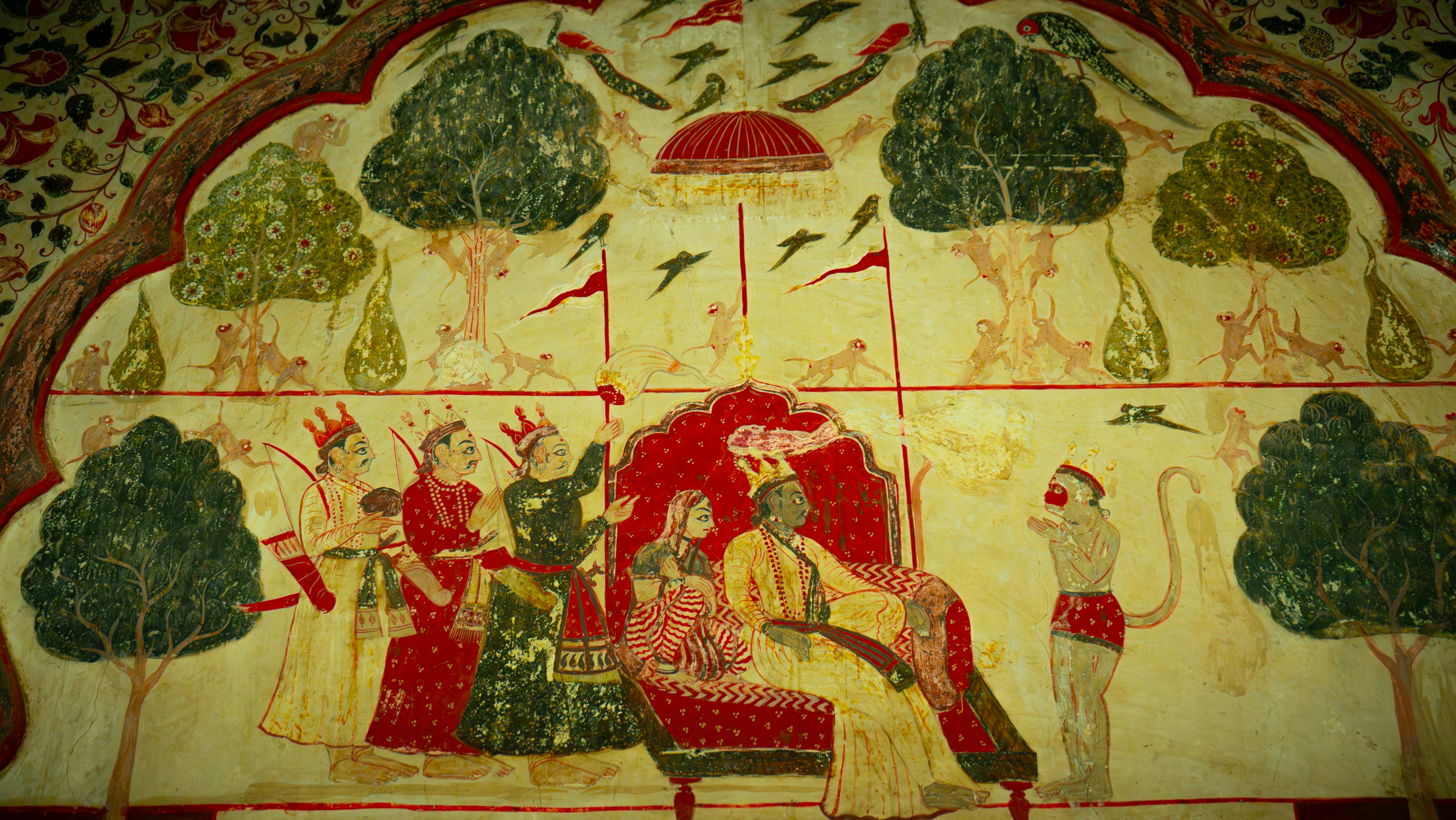 Mural depicting a royal court scene with figures and trees.