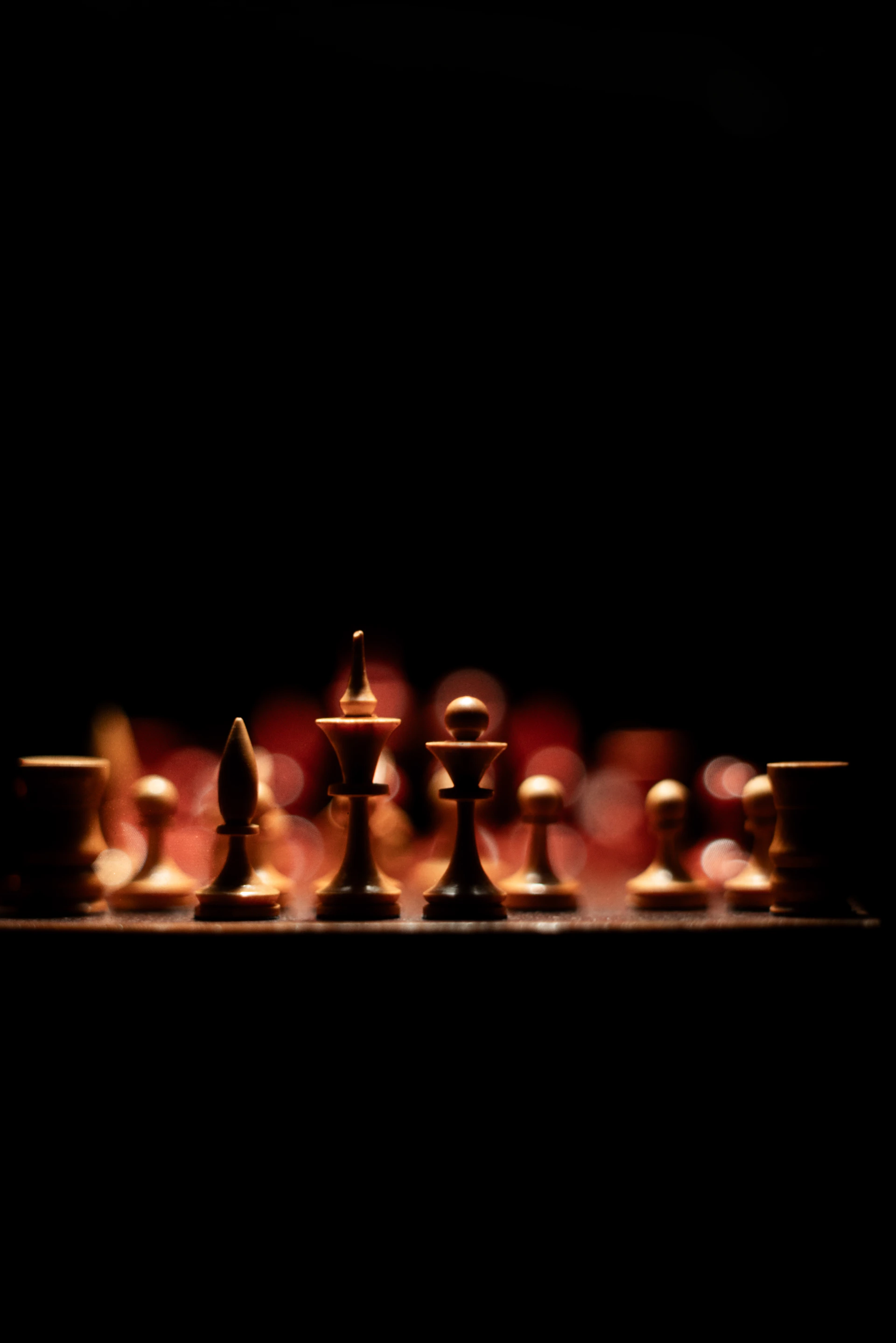 Chess pieces lined up on a dark background