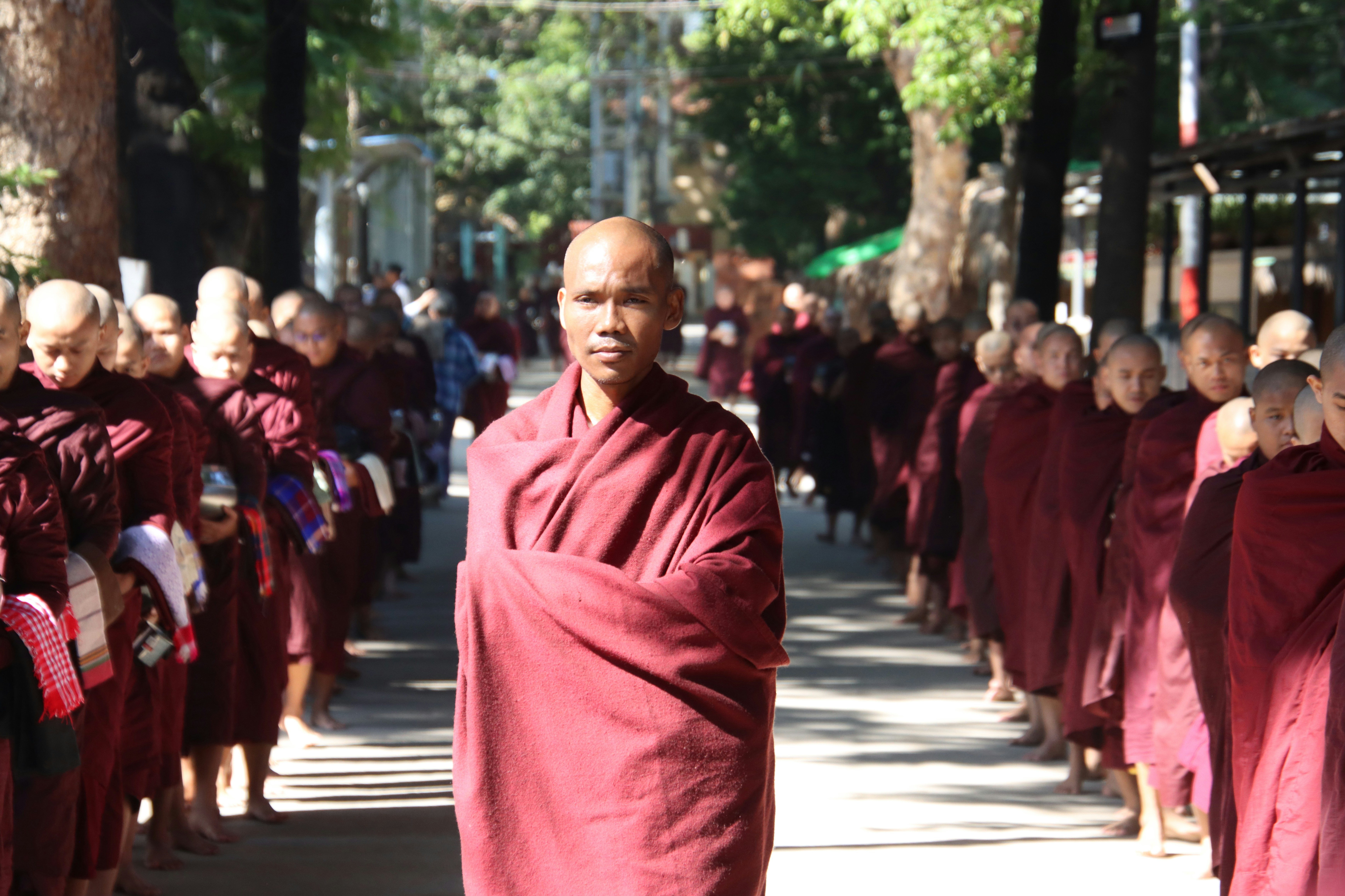 A group of buddhist monks in maroon robes walking