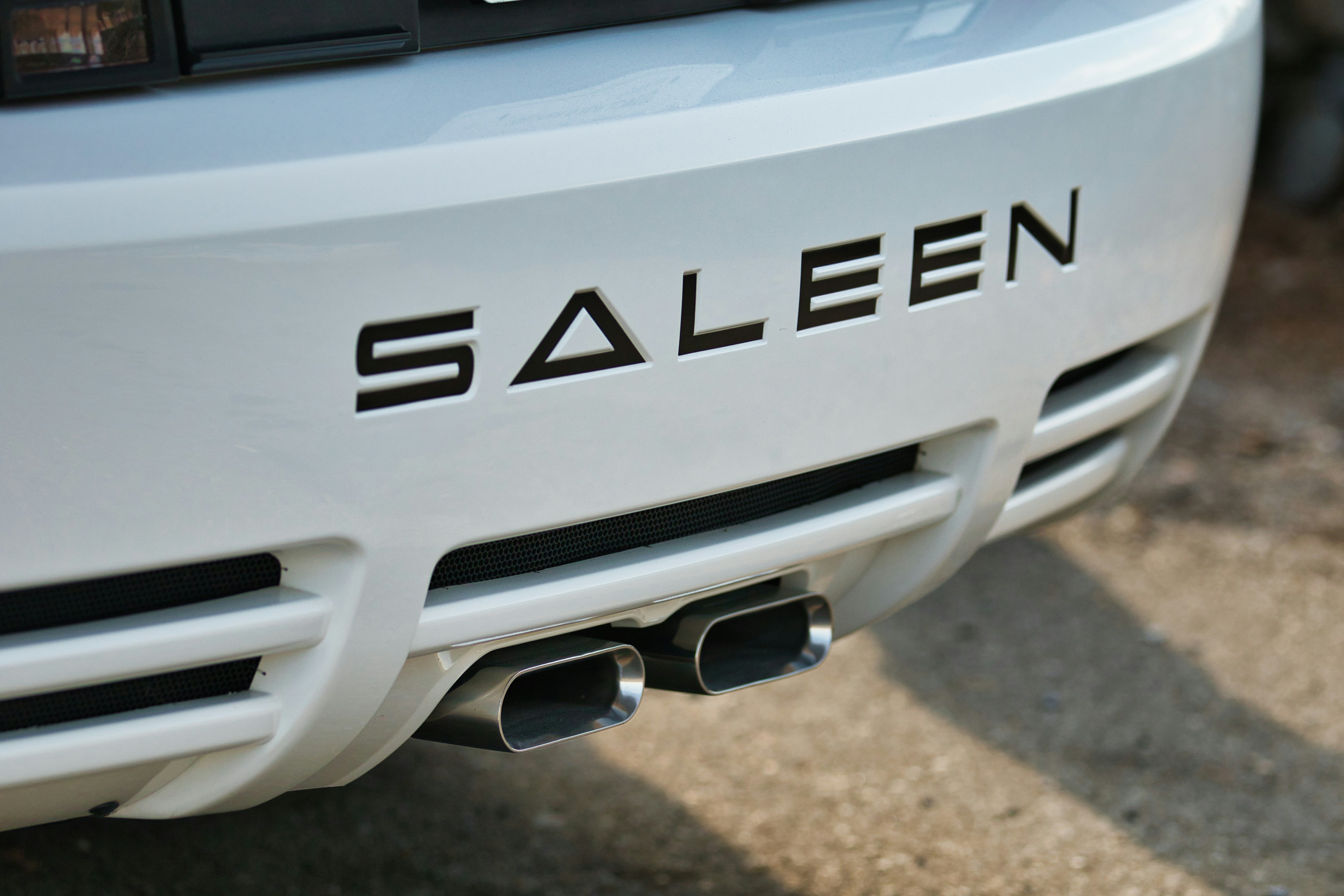 White car with saleen badging and dual exhaust pipes