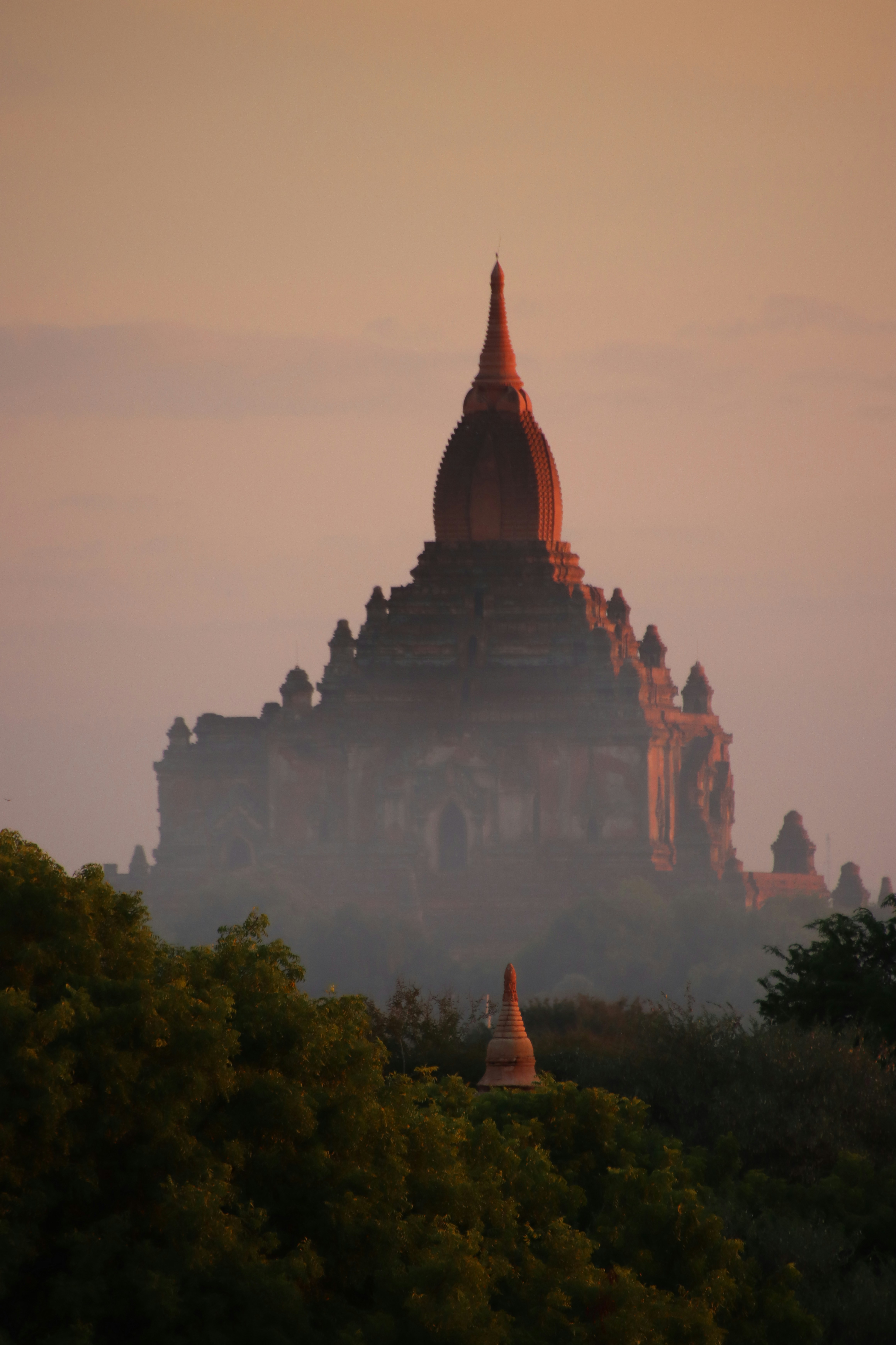 Ancient temple silhouette at sunrise with misty atmosphere